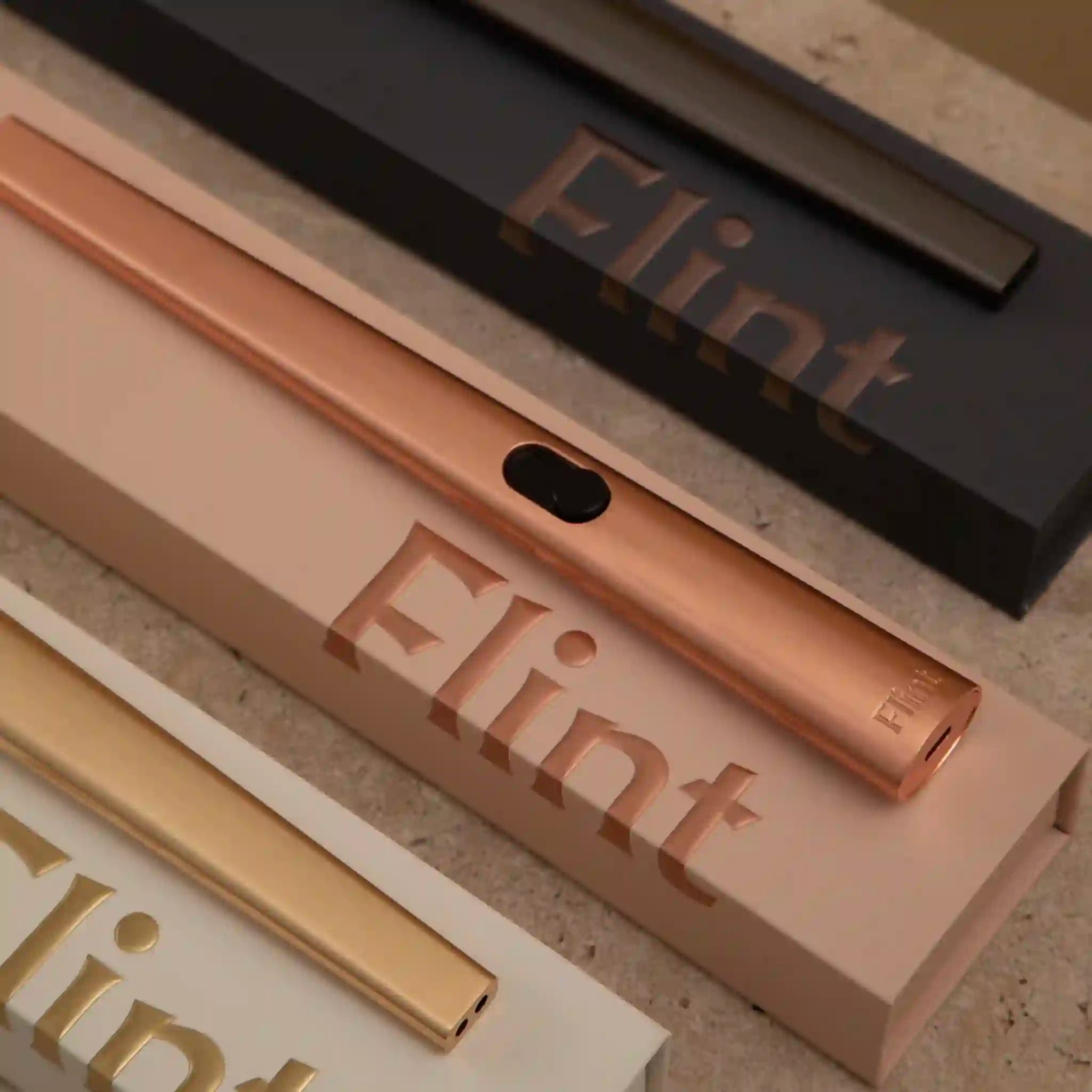 Bronze, gold, and black 'Flint' branded products on a textured surface
