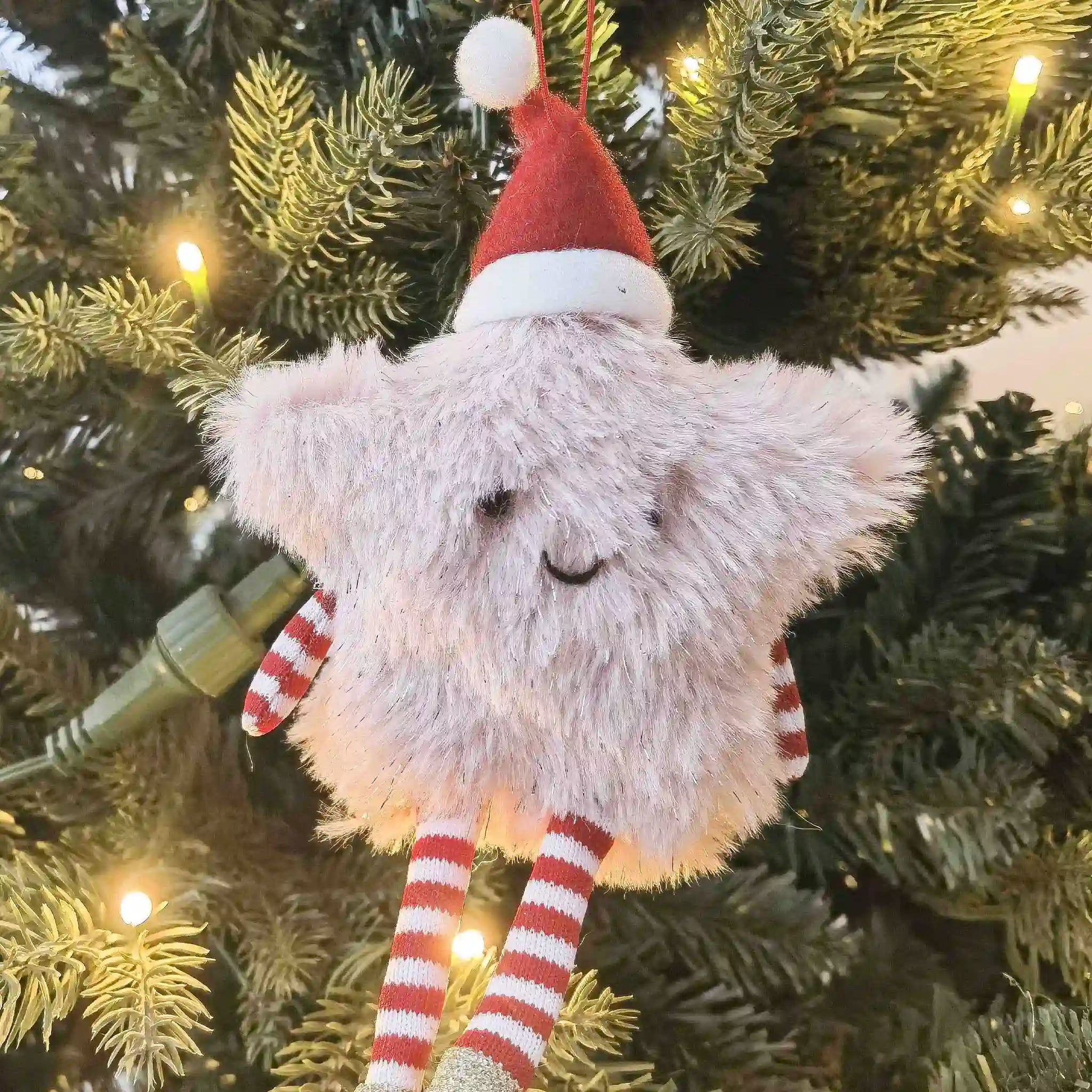 Plush Santa Claus toy hanging on a Christmas tree