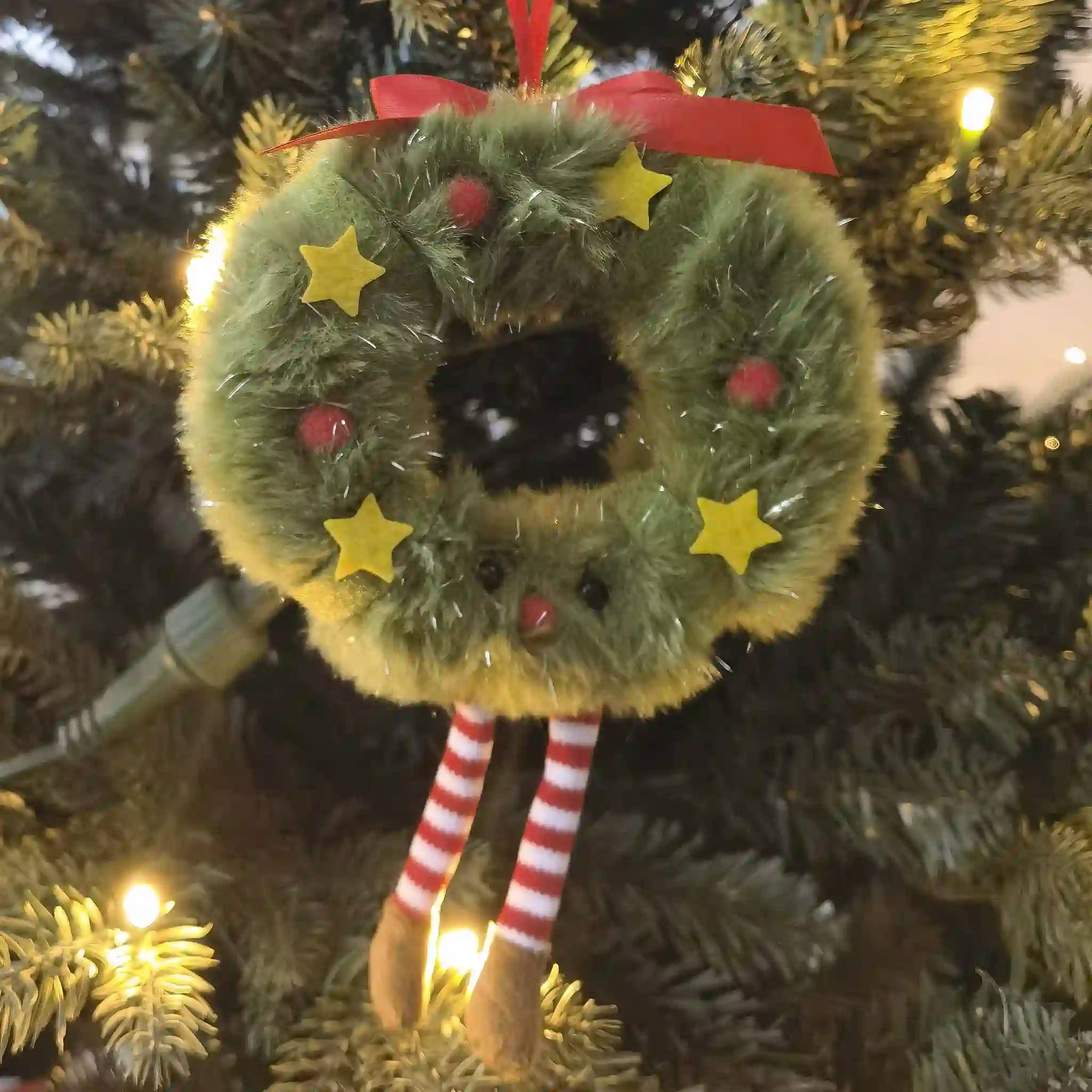 Christmas ornament shaped like a wreath with a reindeer face on a tree.