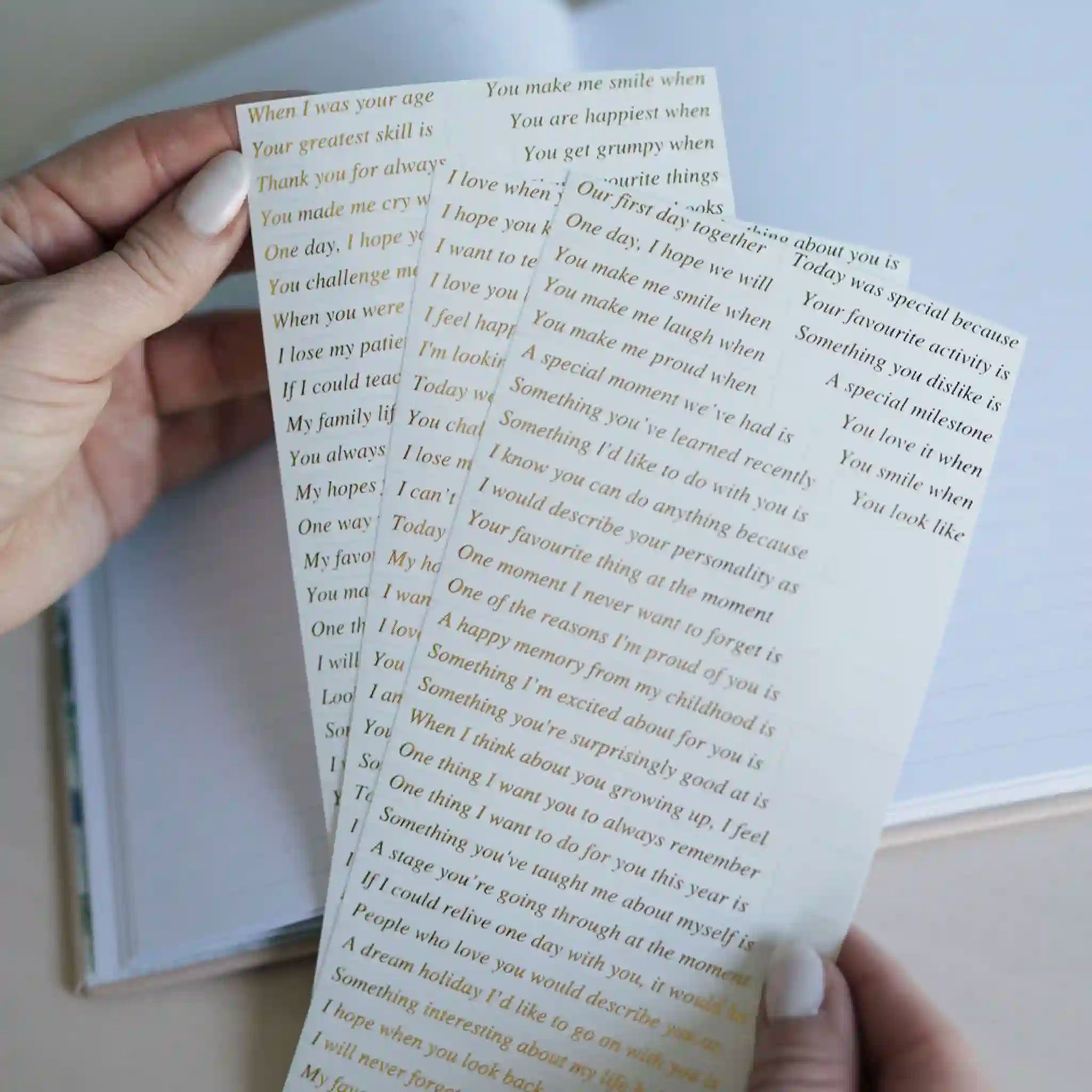 Hand holding a small booklet with printed text