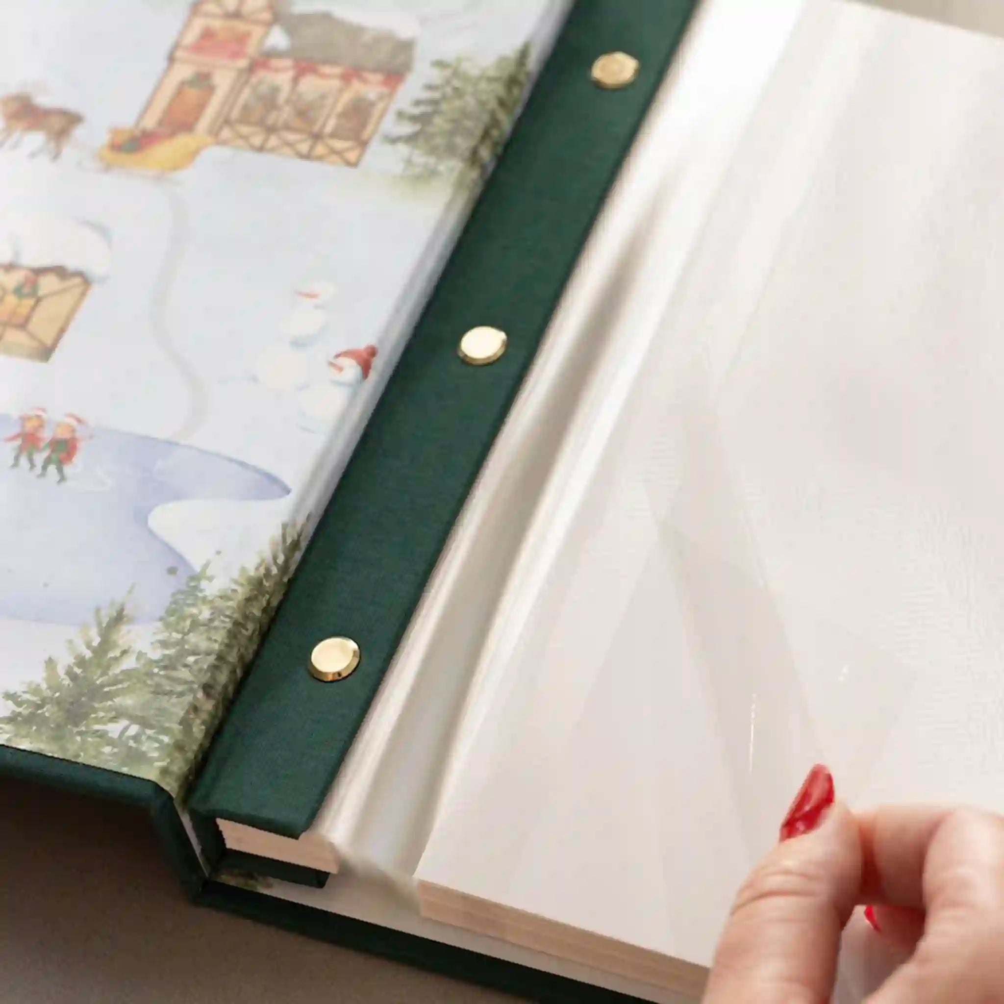 Open book with green leather binding and a hand holding it