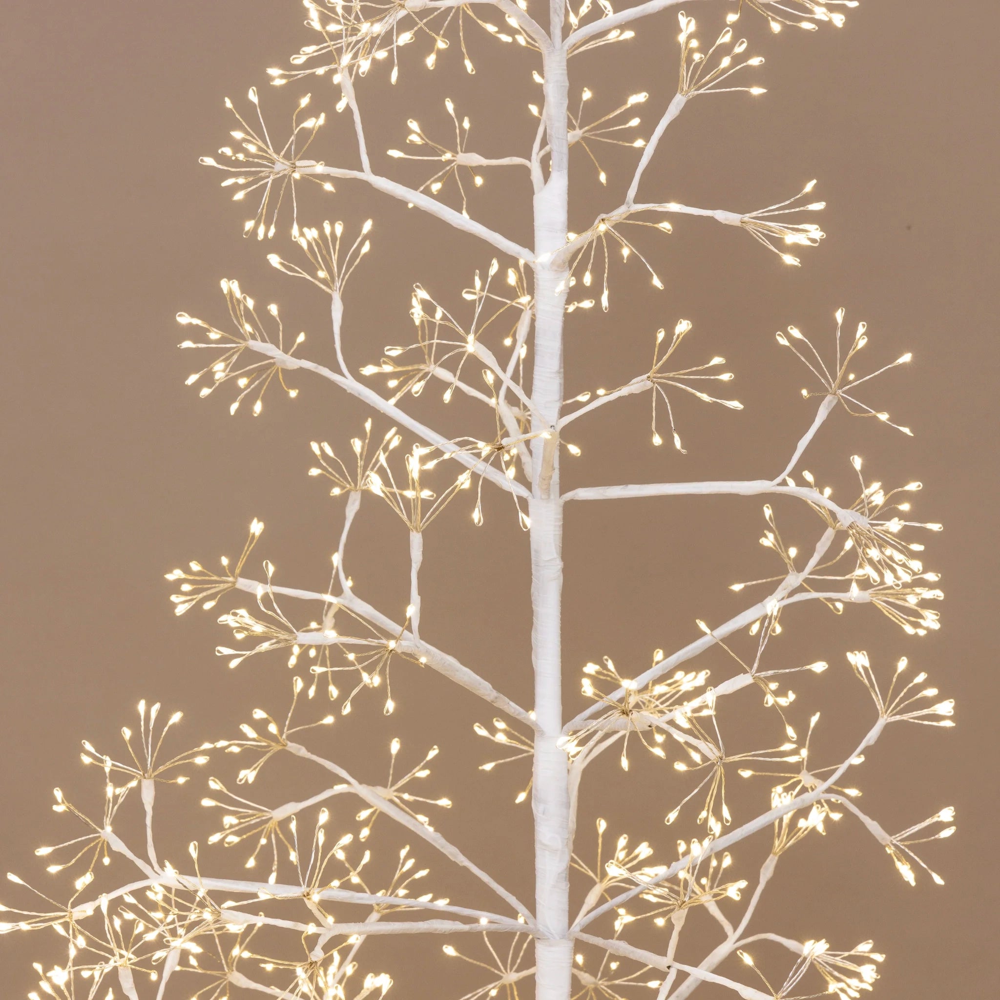 Decorative white tree with small lights on a brown background