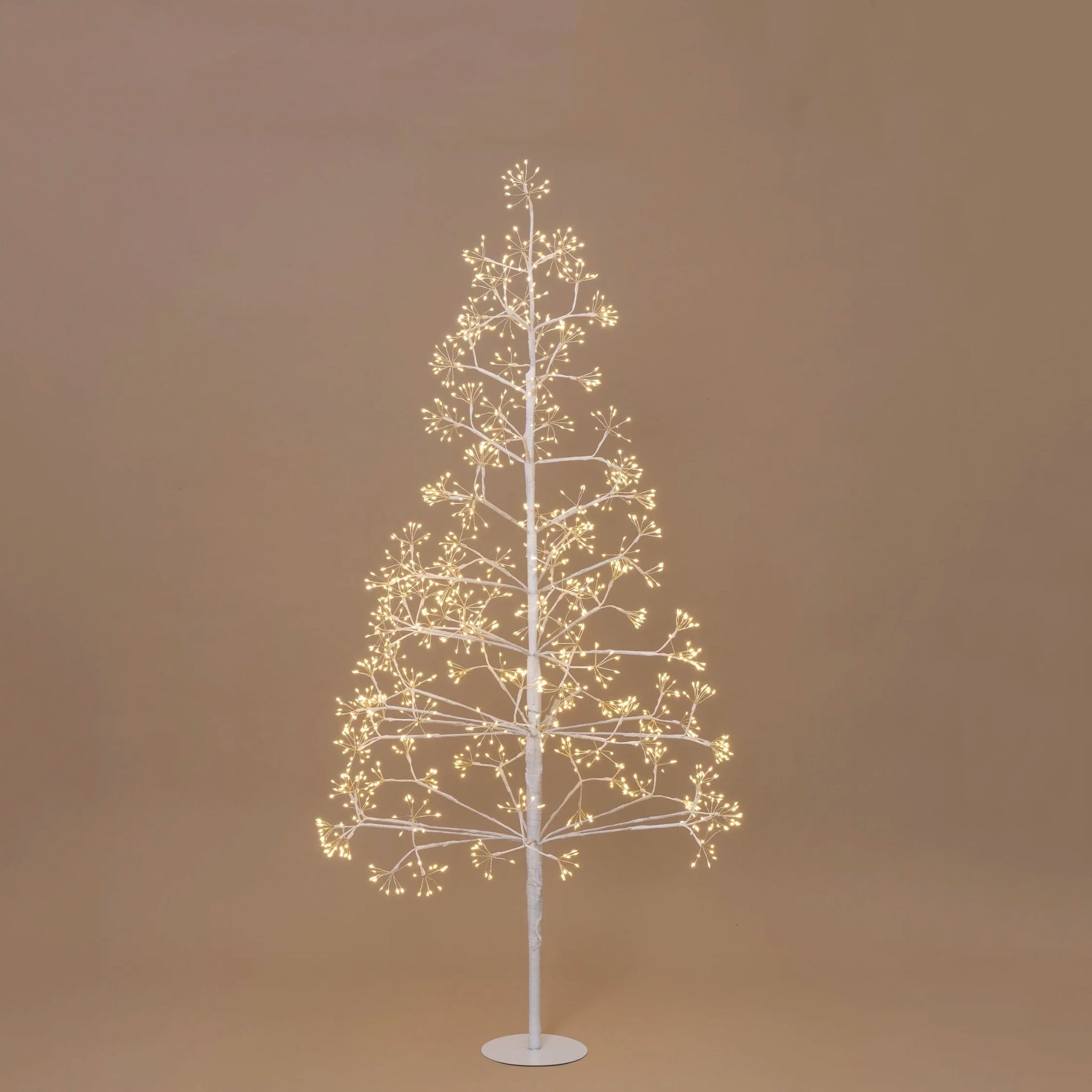 Decorative LED tree with warm white lights on a beige background