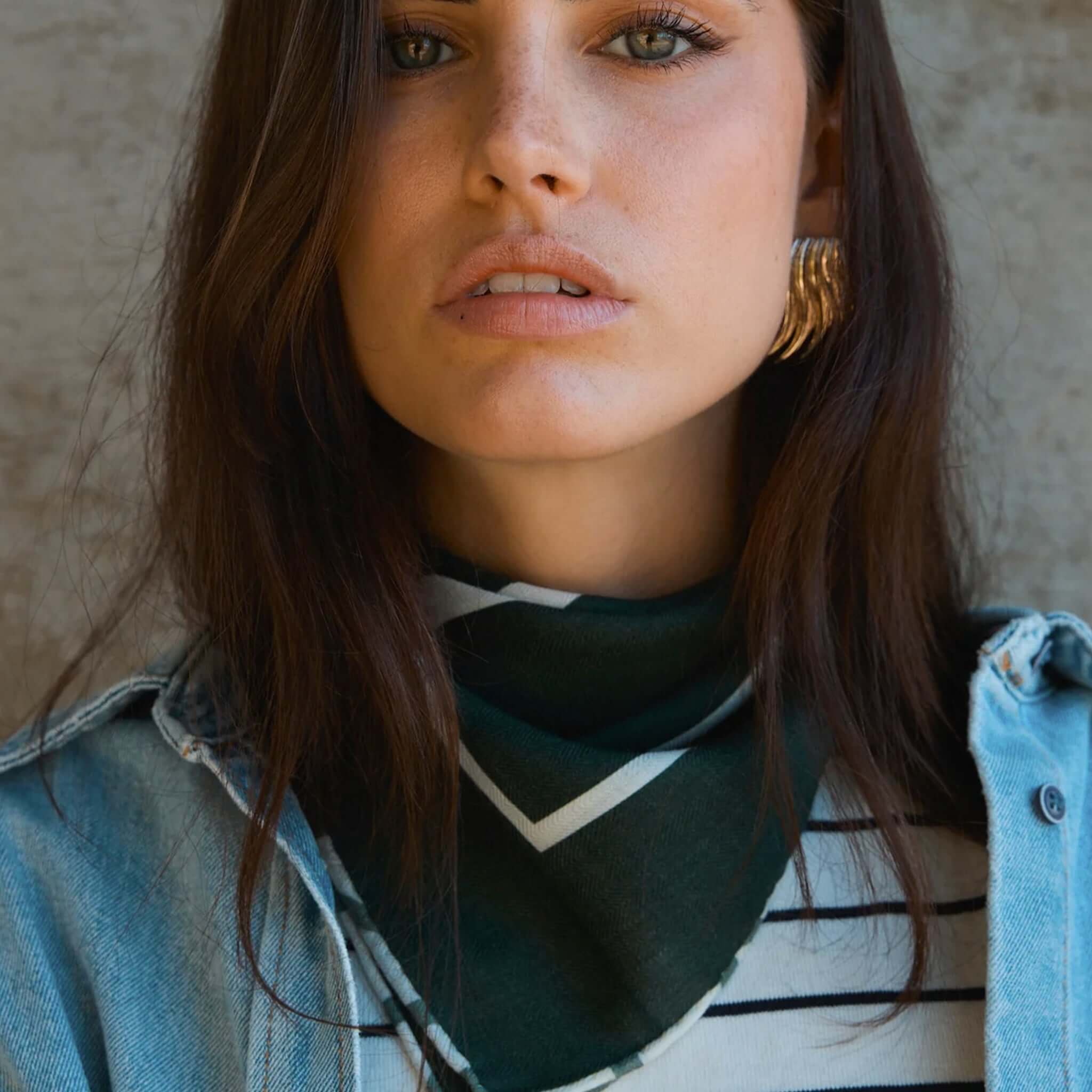Alt Tag: Good & Co Heritage Neckerchief Wool & Silk Scarf - Forest worn as a forest green neckerchief on model, double-sided herringbone