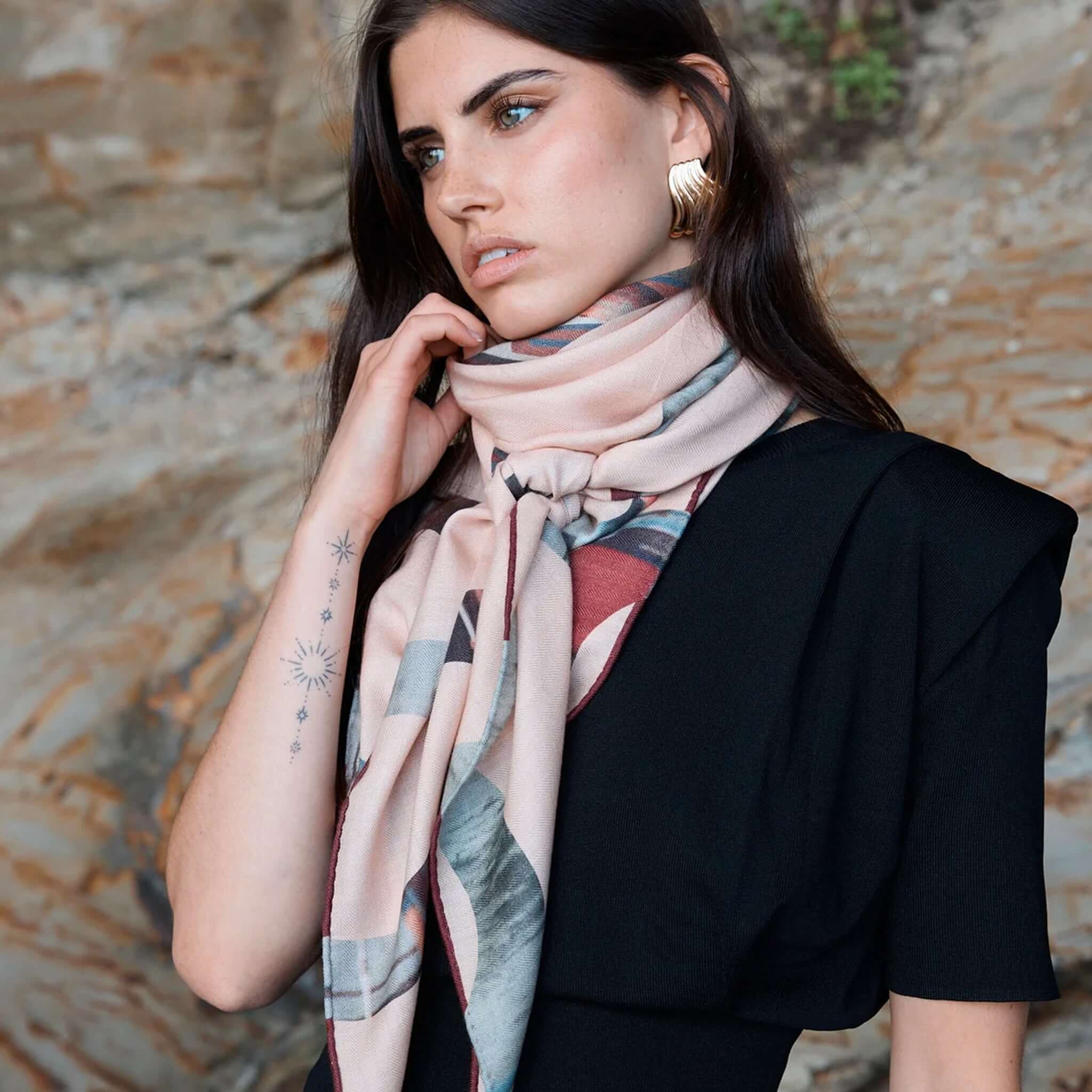 Alt Tag: Good & Co Heritage Triangle Wool & Silk Scarf - Blush worn as a blush pink oversized triangle scarf with heritage logo print