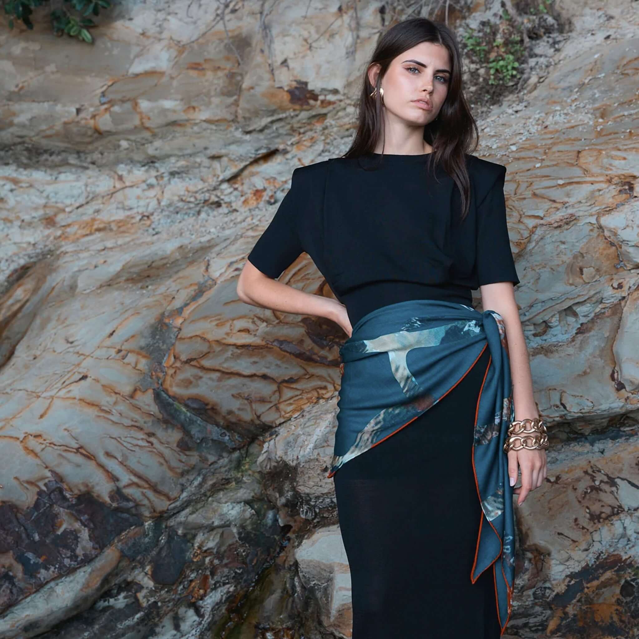 Alt Tag: Model wearing Good & Co Heritage Triangle Wool & Silk Scarf - Petrol, oversized triangle wool-silk herringbone scarf with contrast hem