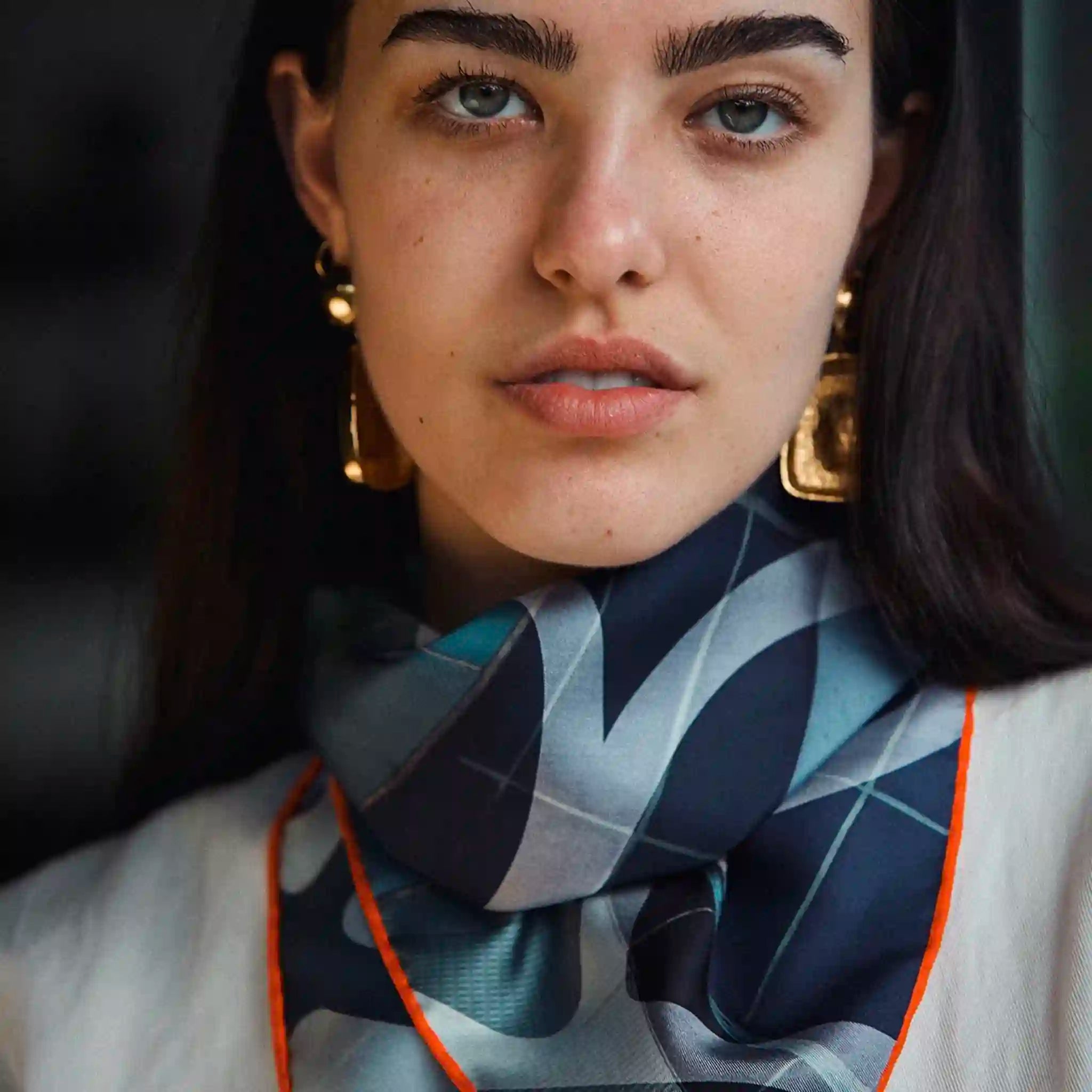 Woman wearing a patterned scarf with a blurred background