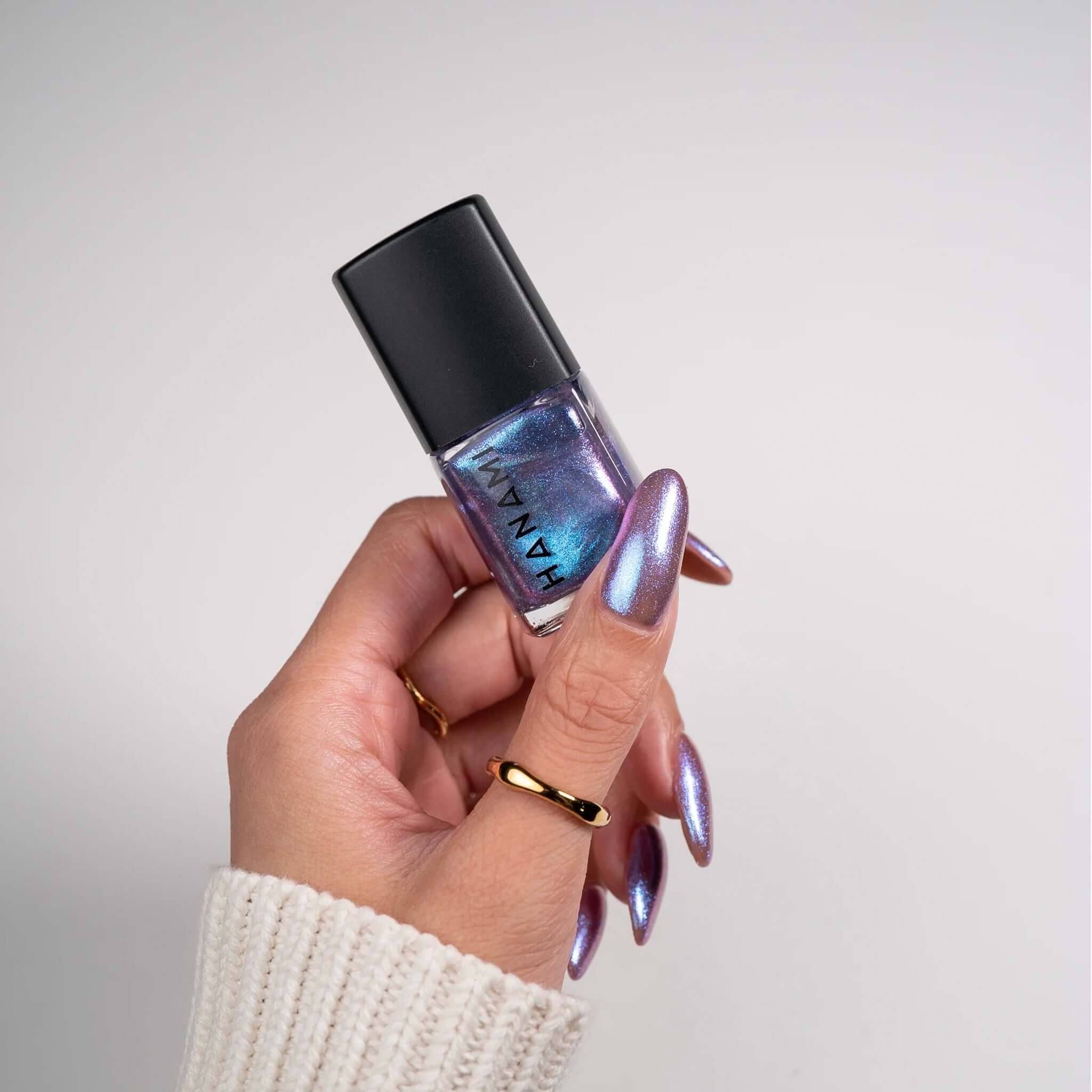Alt Tag: Hanami Plant Based Nail Polish - Mood Ring holographic plant-based vegan 21-free nail polish bottle held in hand with shimmering nails