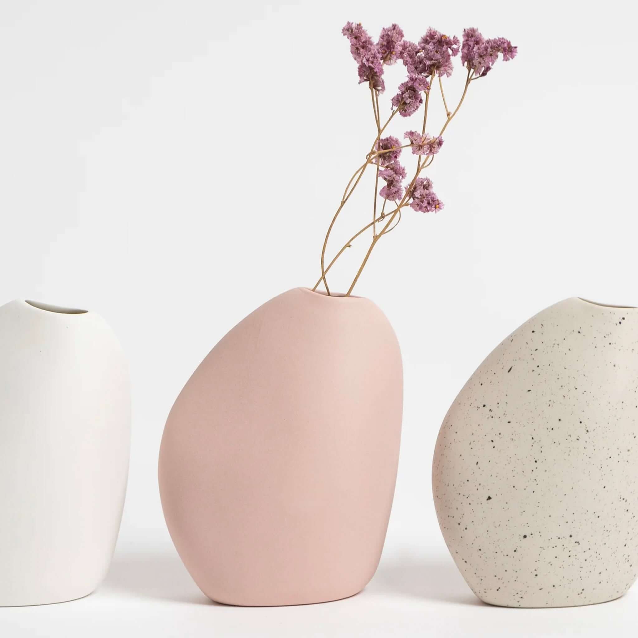 Harmie Ceramic Great Vase - Blush Pink with dried flowers, alongside two other ceramic vases in white and speckled gray.