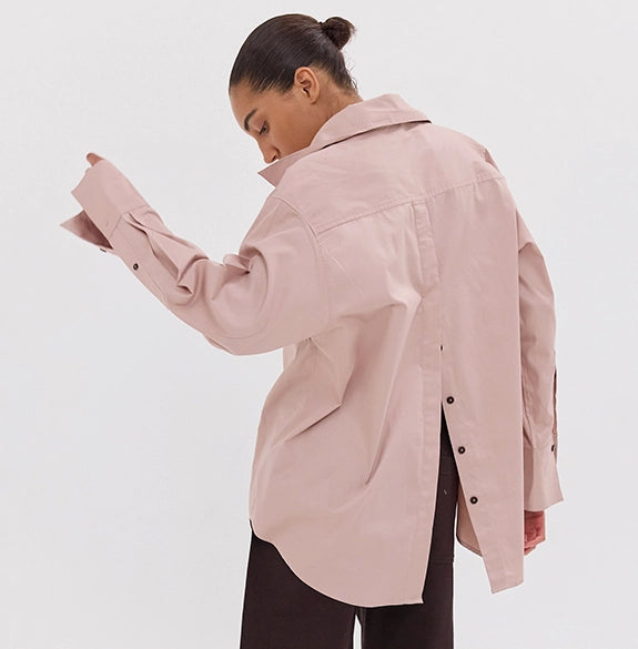 Person wearing a light pink jacket on a white background