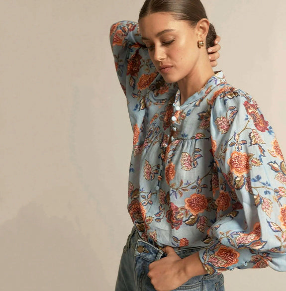 Woman wearing a floral blouse with a neutral background