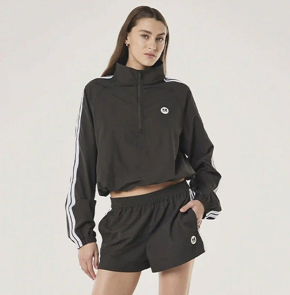 Person wearing a black hoodie and shorts with a brand logo on a white background