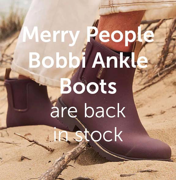 Purple ankle boots on a sandy background with text about Merry People Bobbi Ankle Boots being back in stock.