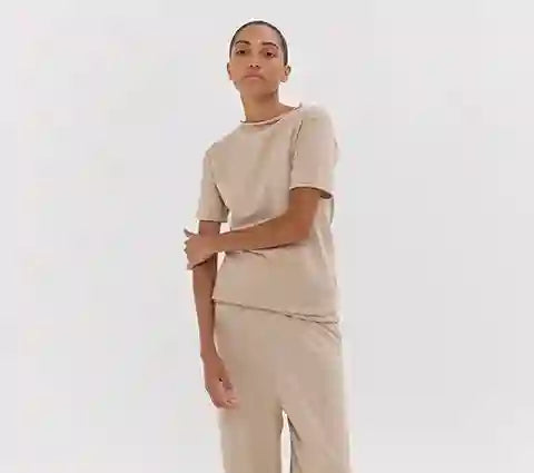 Person wearing a beige outfit on a white background