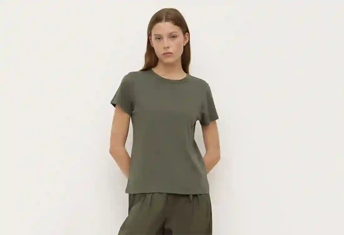 Person wearing a green t-shirt and pants against a white background