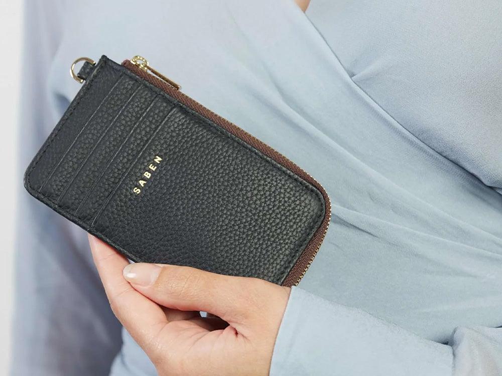 Woman holding a black Winona wallet.