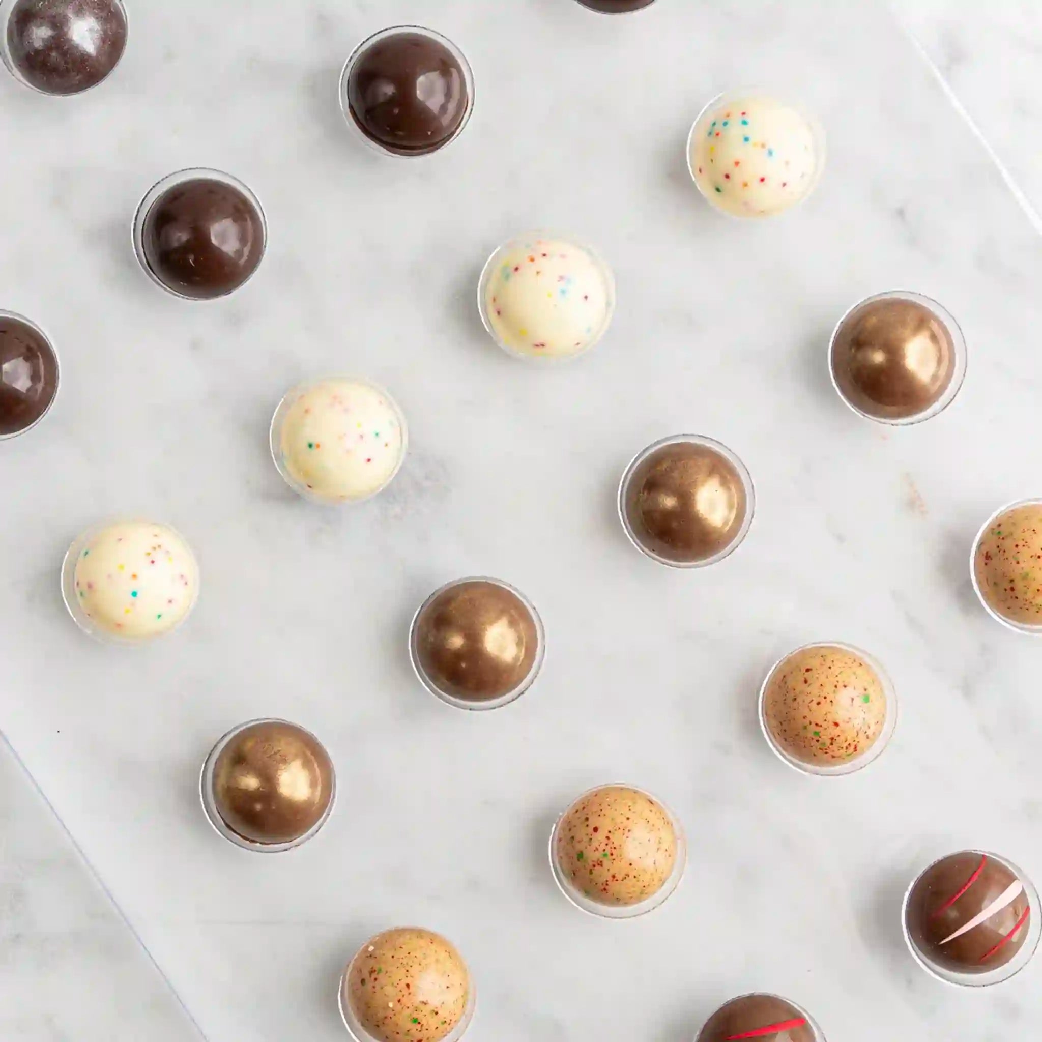 Assorted chocolate truffles on a white surface