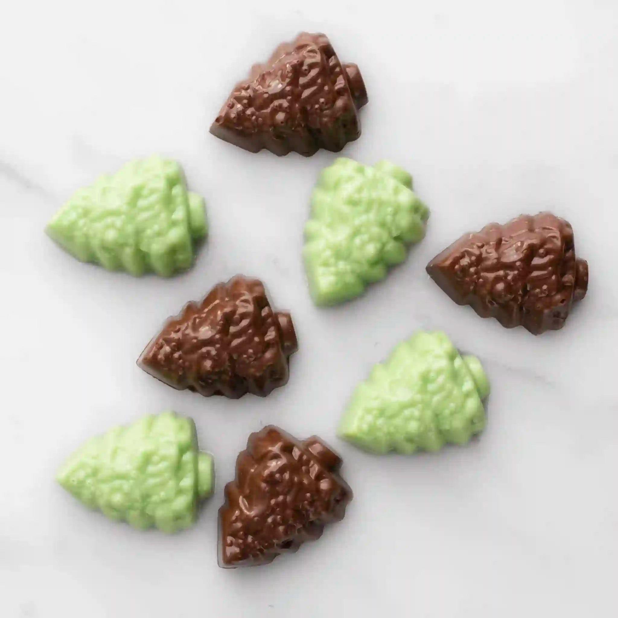 Chocolate candies shaped like pine cones on a white surface