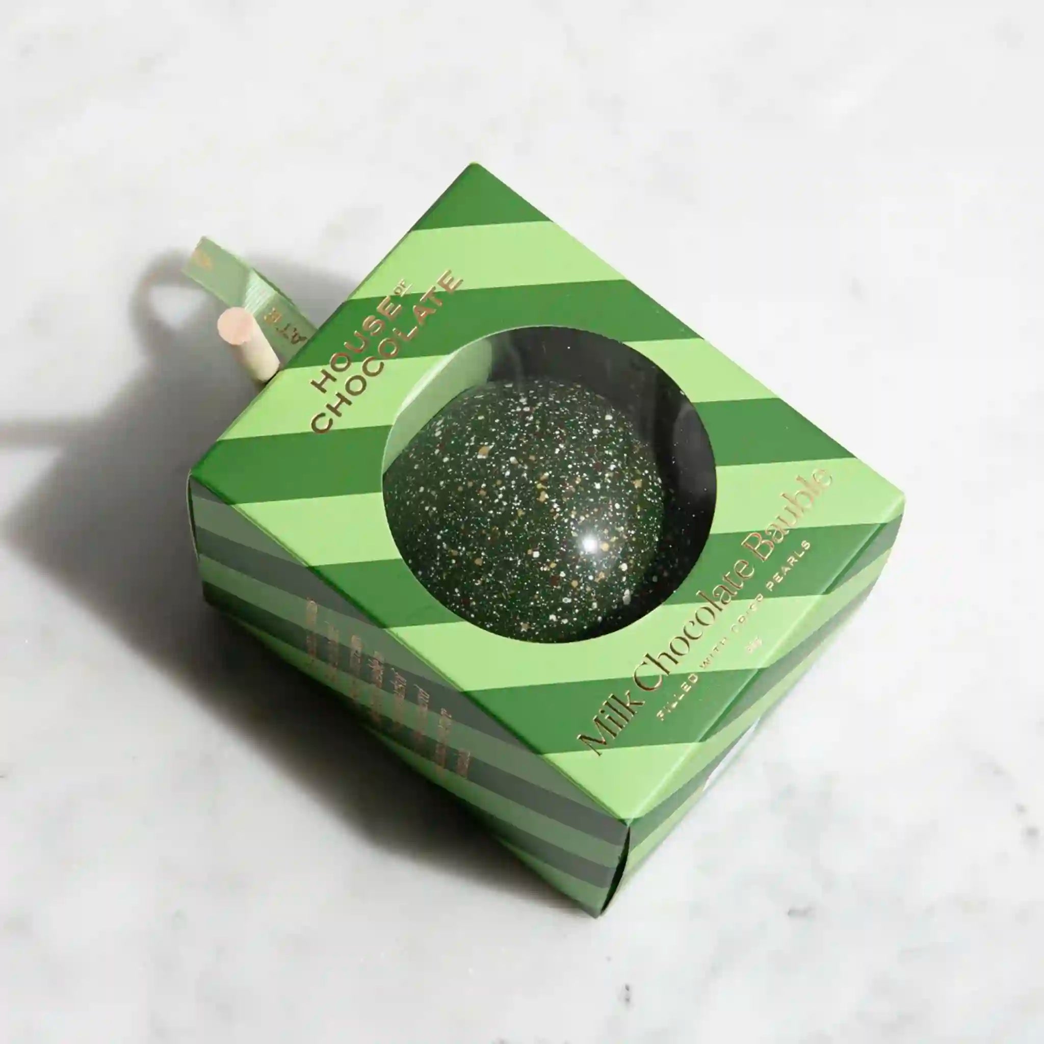 Green glittery chocolate in a striped box on a white background