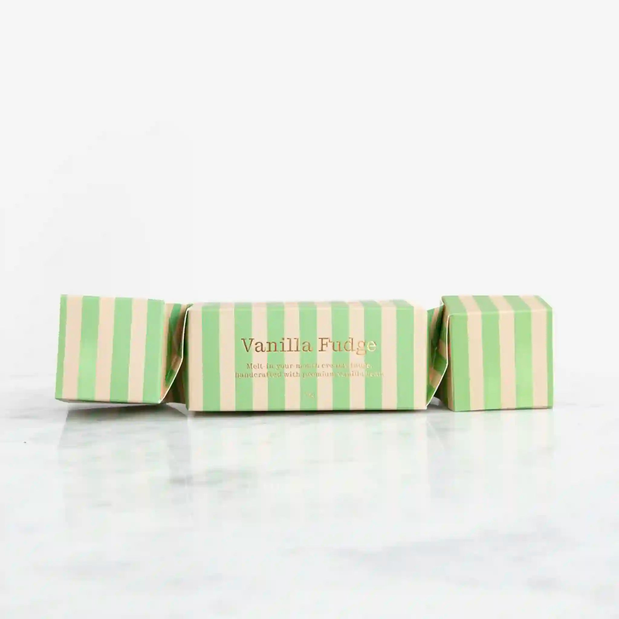 Green and white striped box of vanilla fudge on a white background