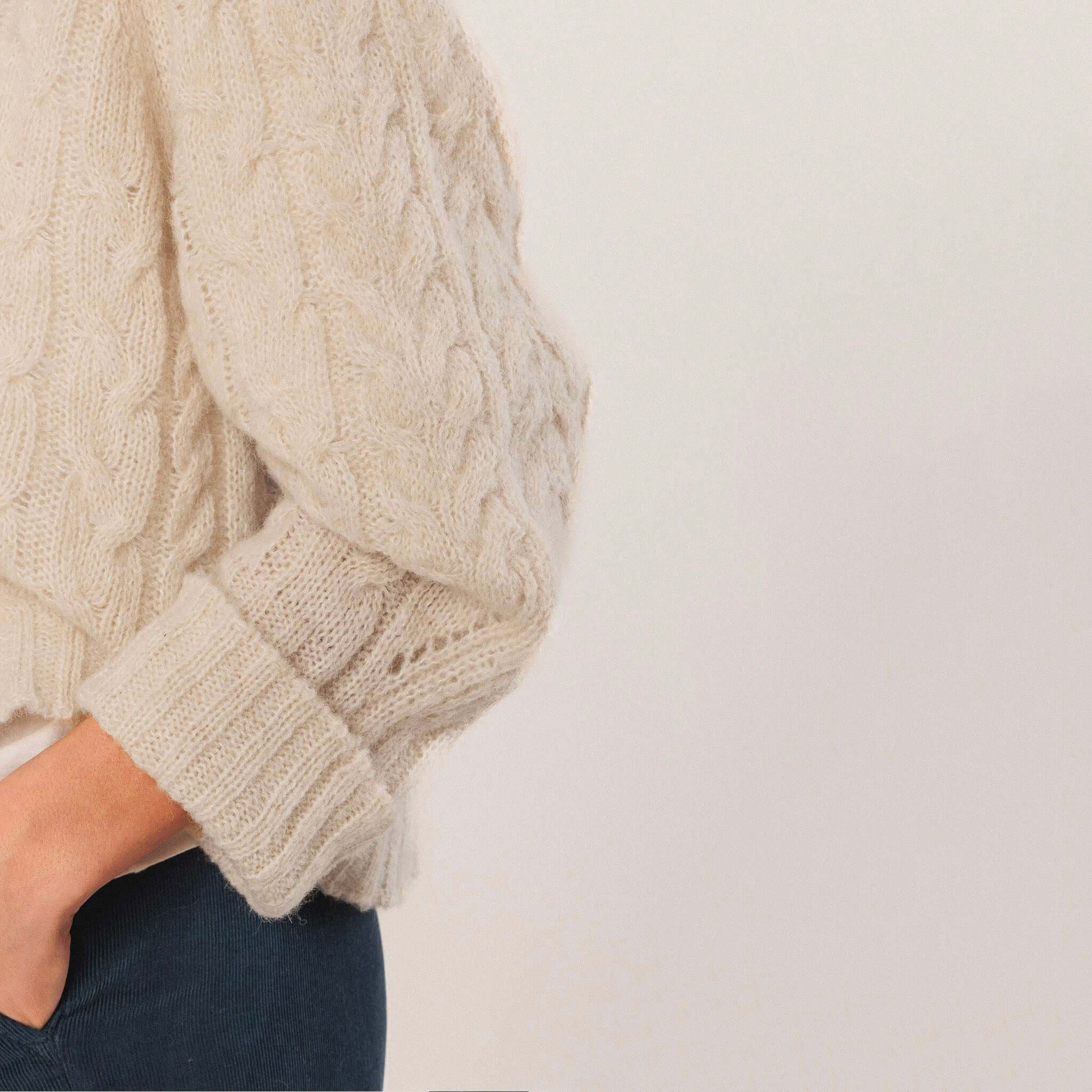 Alt Tag: Indi & Cold Cable Knit Aplaca Blend Jersey - Crudo off-white alpaca blend braided cable knit sweater sleeve detail