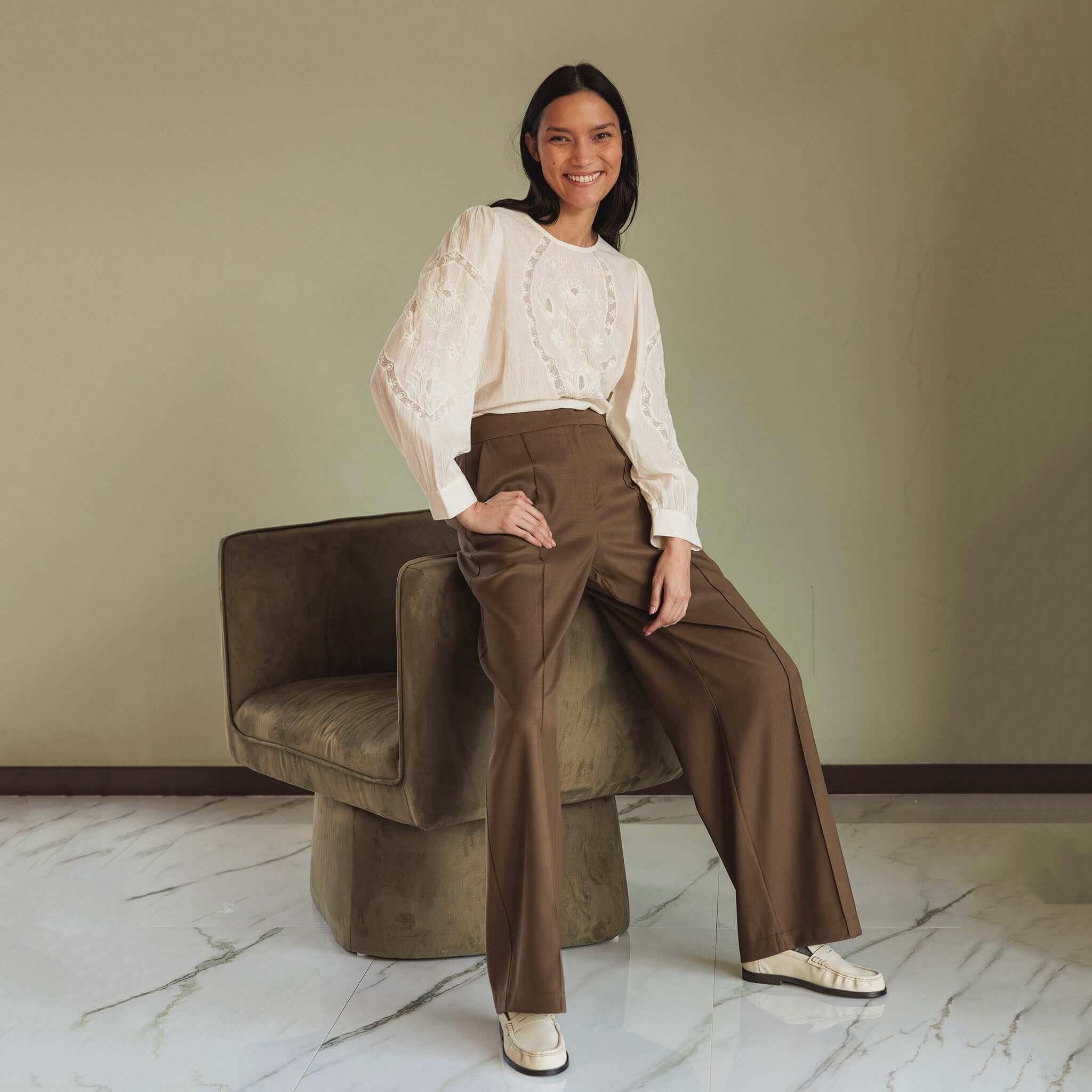 Indi & Cold Organic Cotton Romantic Embroidered Blouse - White on model, floral embroidery details, long sleeves, styled with wide-leg trousers