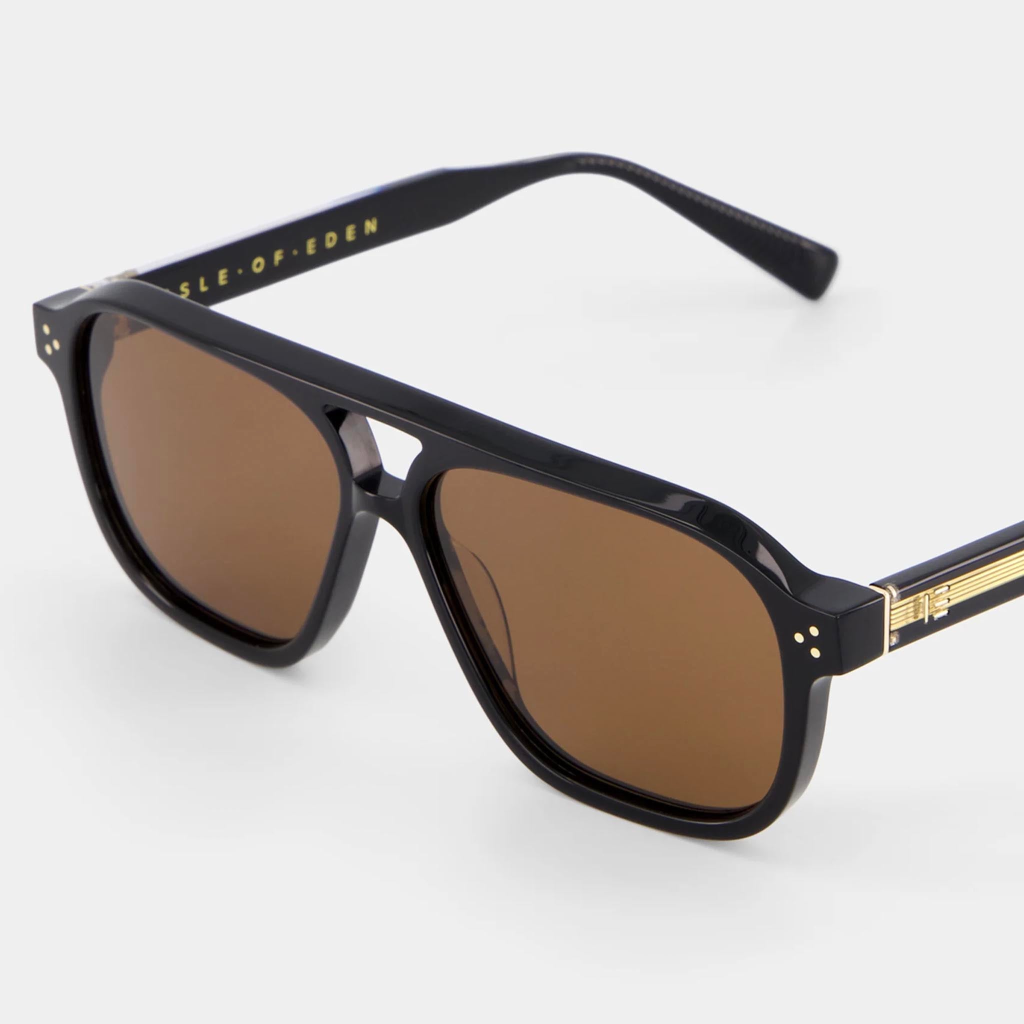 Black sunglasses with gold accents on a white background