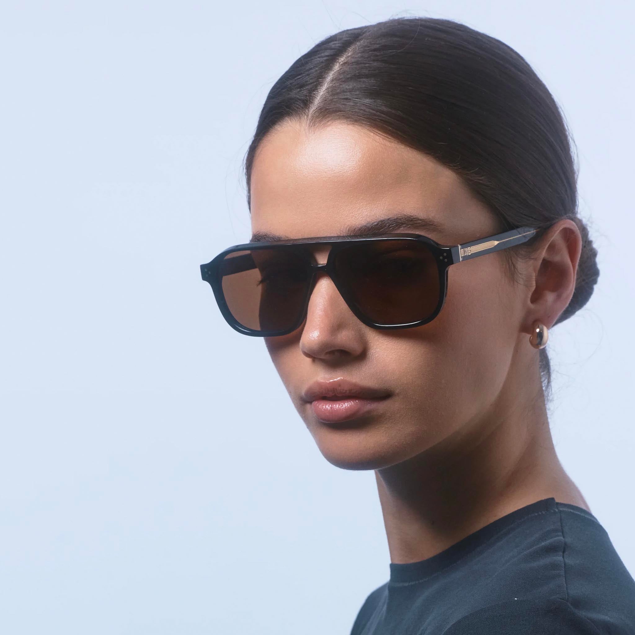 Person wearing dark sunglasses against a light background