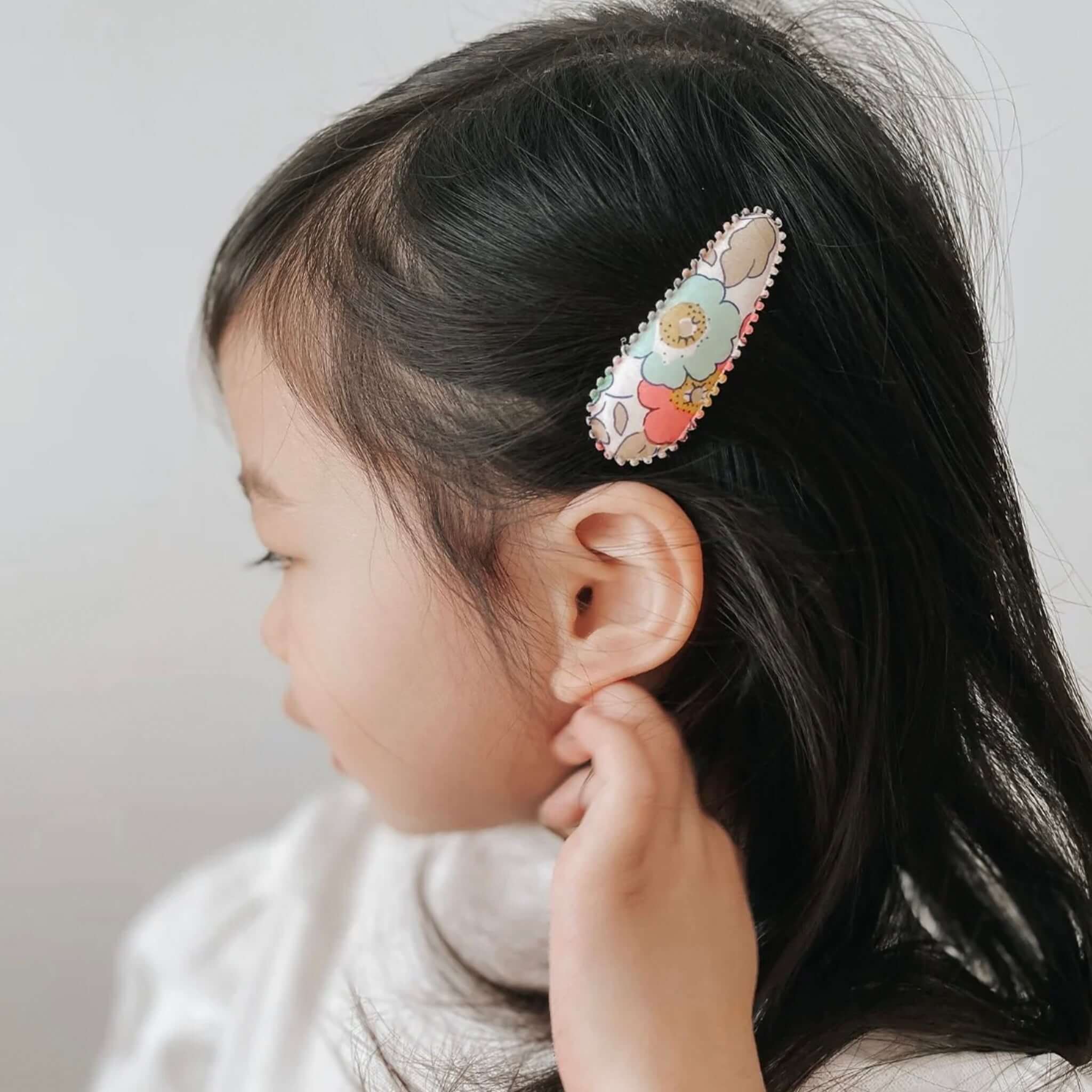Alt Tag: Josie Joan's Hair Clip Set - Poppy fabric snap clip with scalloped edge floral Liberty London print on child’s hair