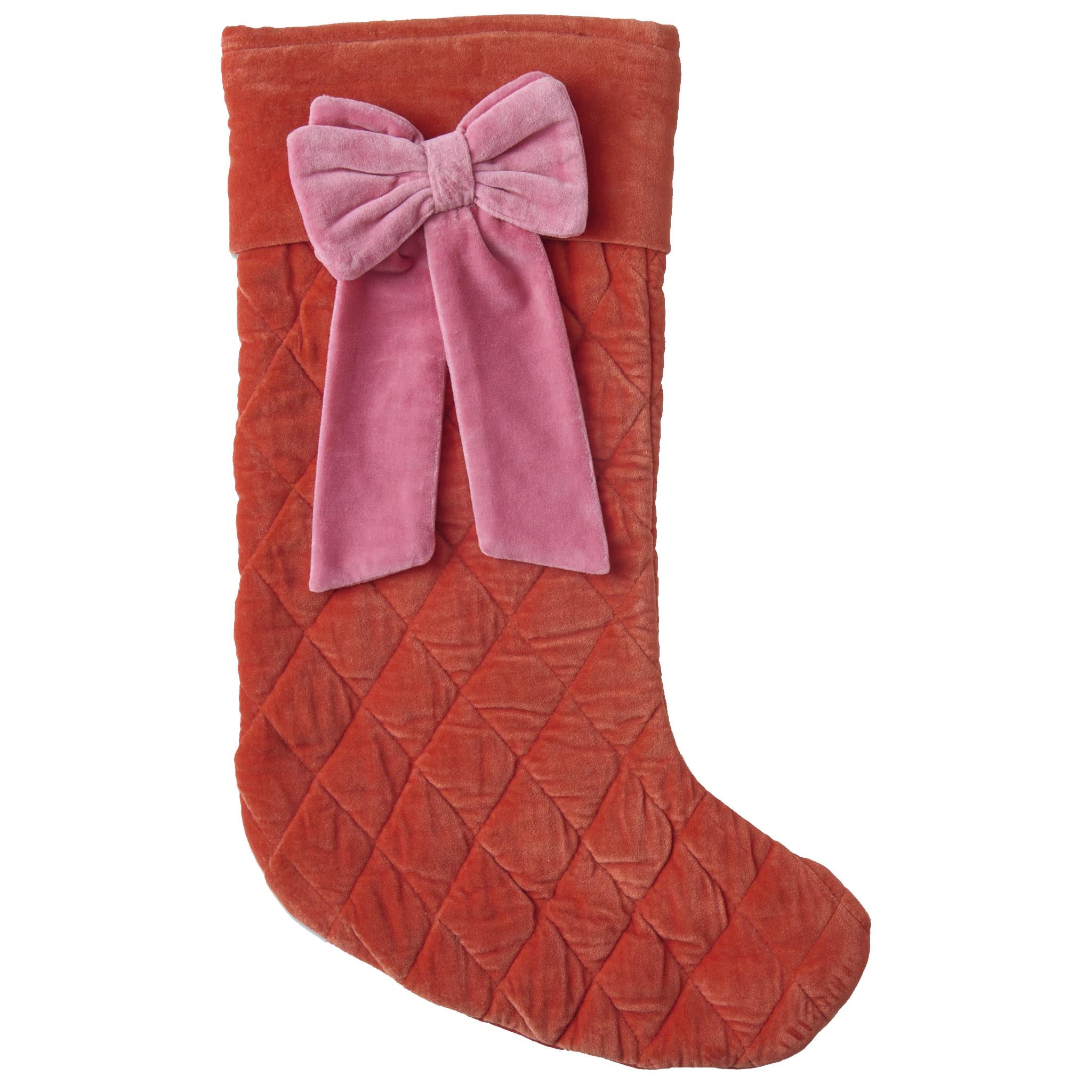 Red quilted Christmas stocking with a pink bow on a white background