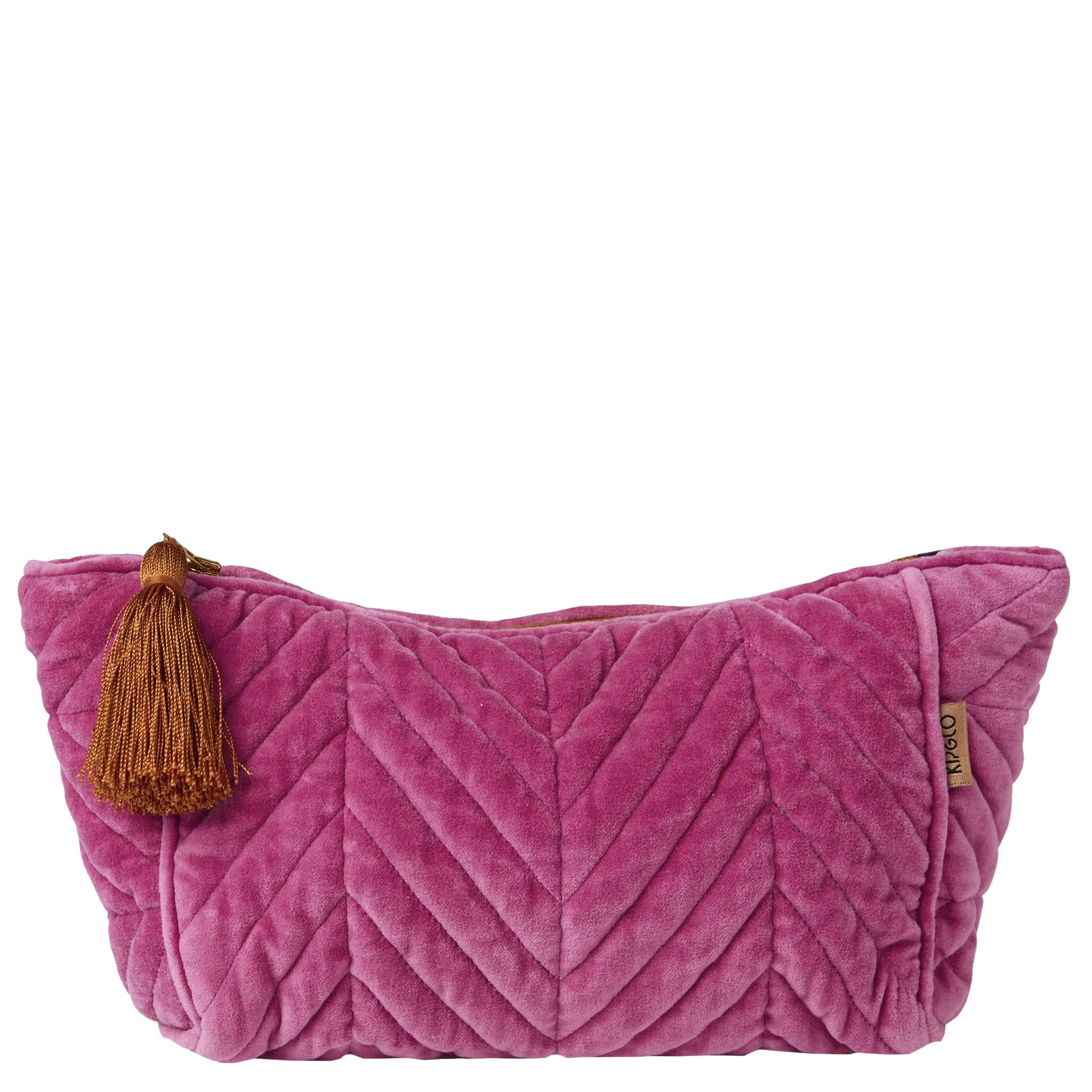 Pink velvet toiletry bag with a brown tassel on a white background