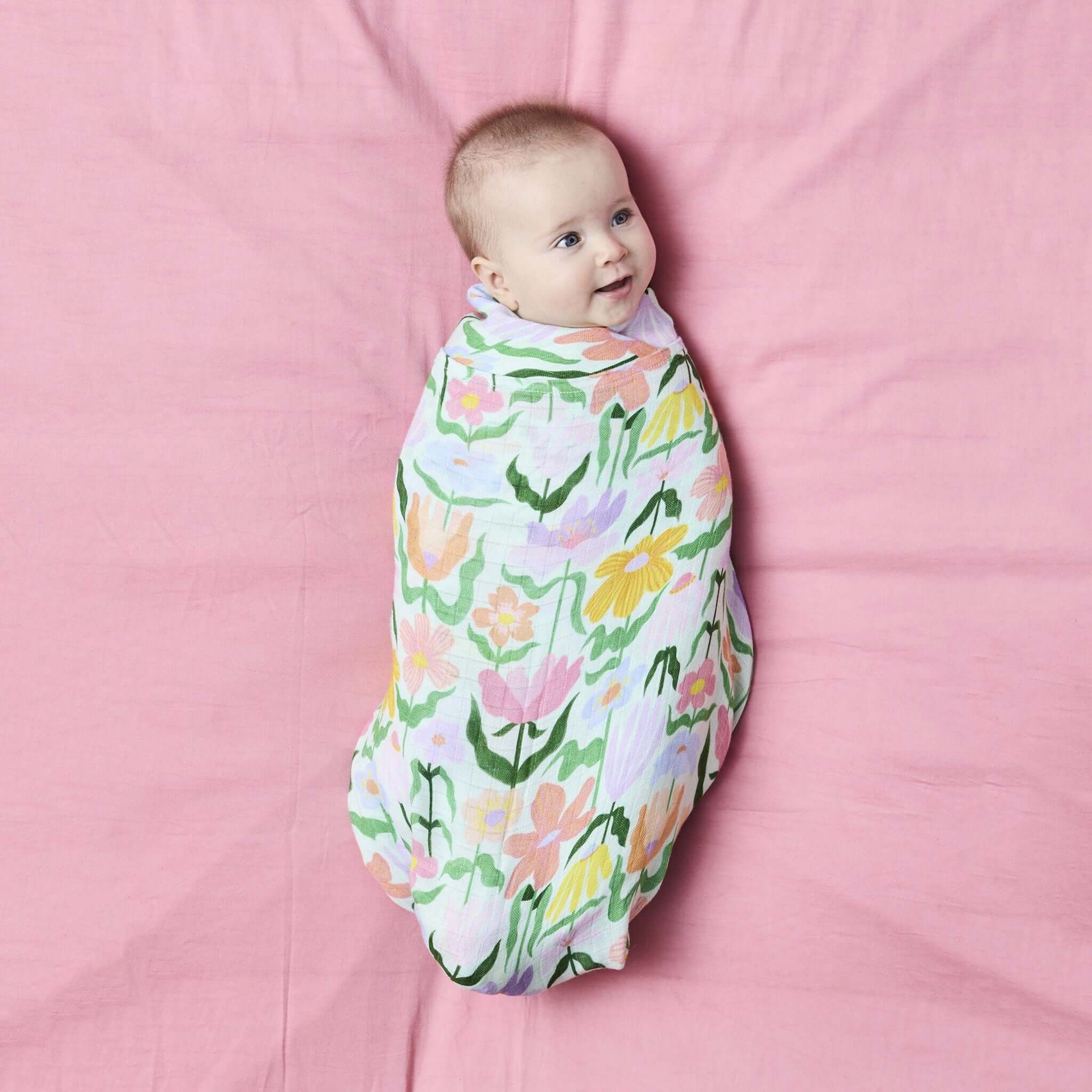 Alt Tag: Kip & Co Bamboo Swaddle - Popping Flowers Green baby wrapped in soft breathable bamboo swaddle with pastel floral print