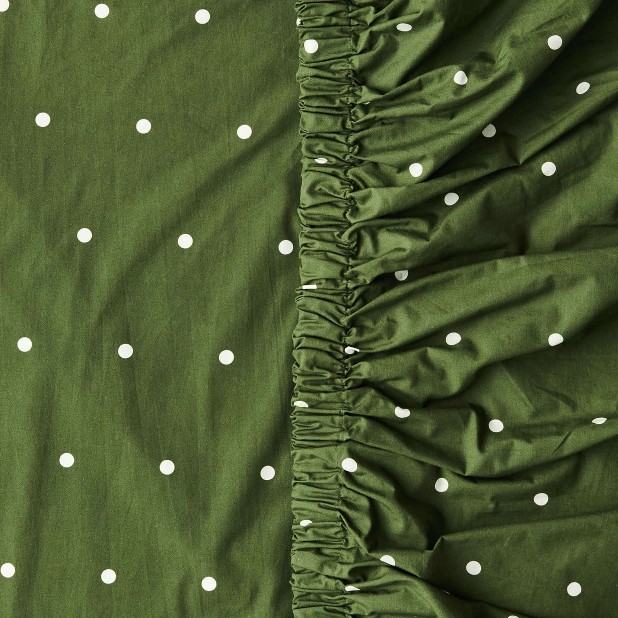 Alt Tag: Kip & Co Organic Cotton Baby Fitted Cot Sheet - Polka Dot Cactus cactus green fitted cot sheet with creamy white polka dots