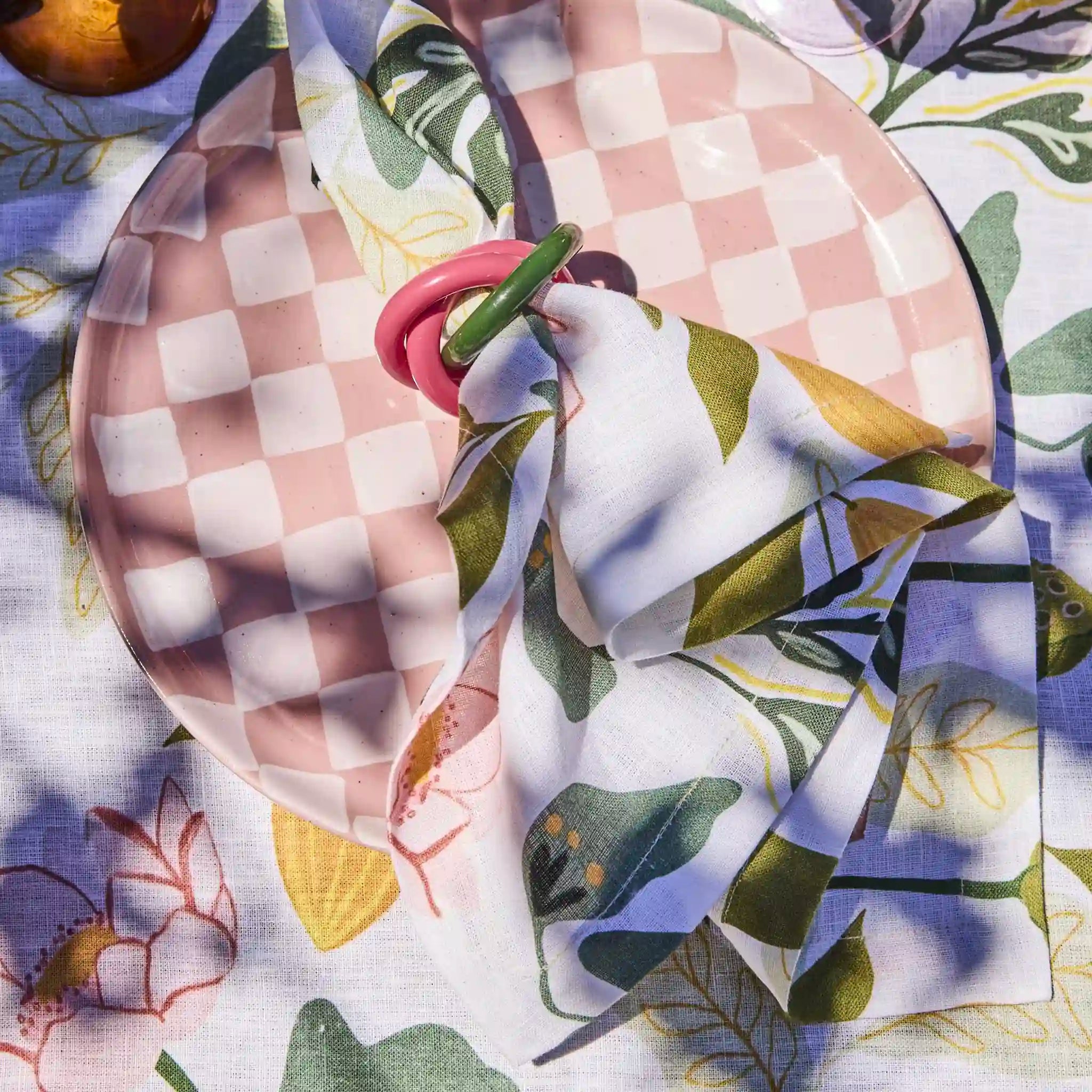 Checkered plate with floral napkin on a patterned tablecloth