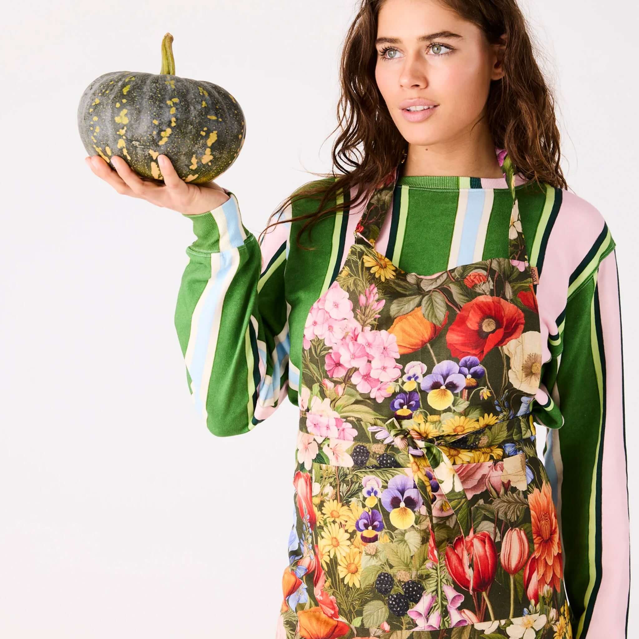 Alt Tag: Kip & Co Linen Apron - Cottage Garden Eden floral linen apron worn by woman holding pumpkin, French flax linen, carbon neutral