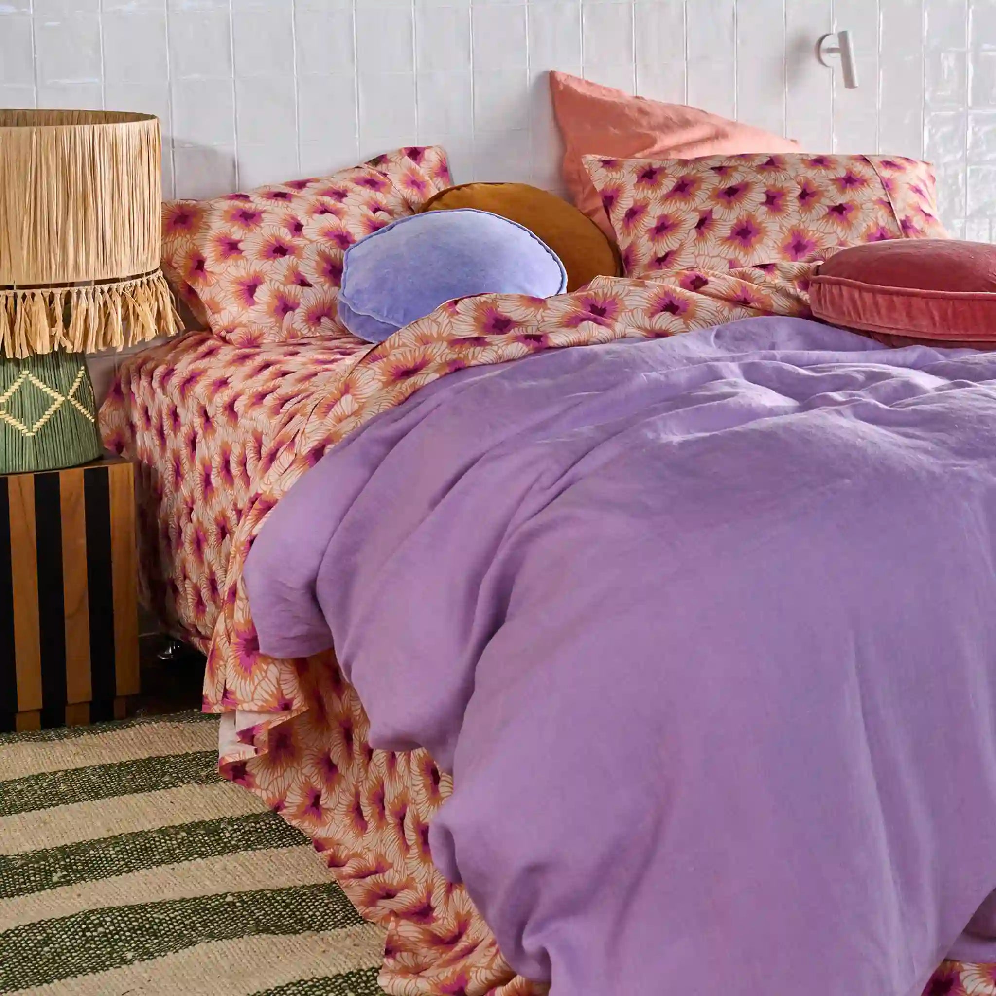 Bed with patterned bedding and pillows in a bedroom setting
