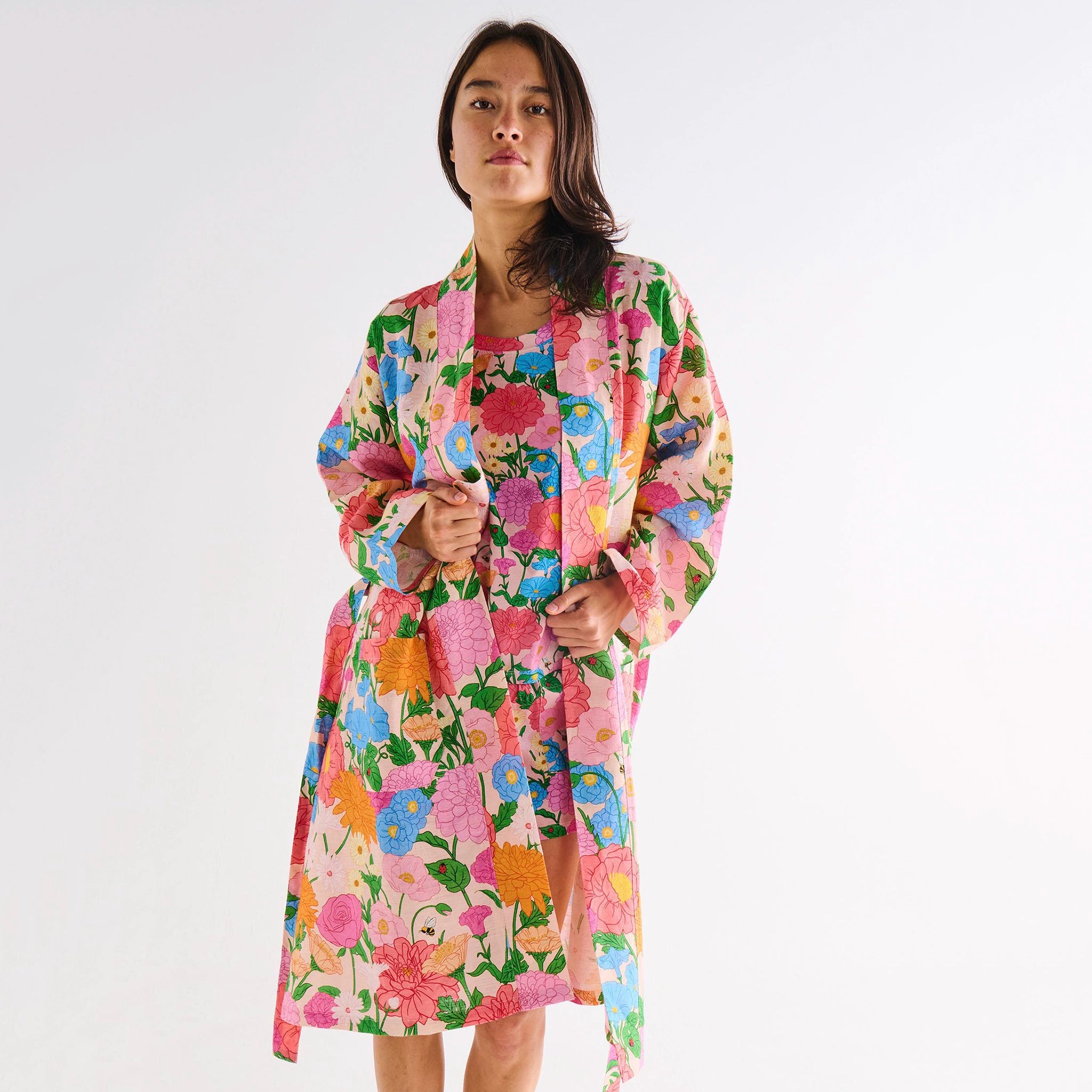 Woman wearing a colorful floral robe on a white background