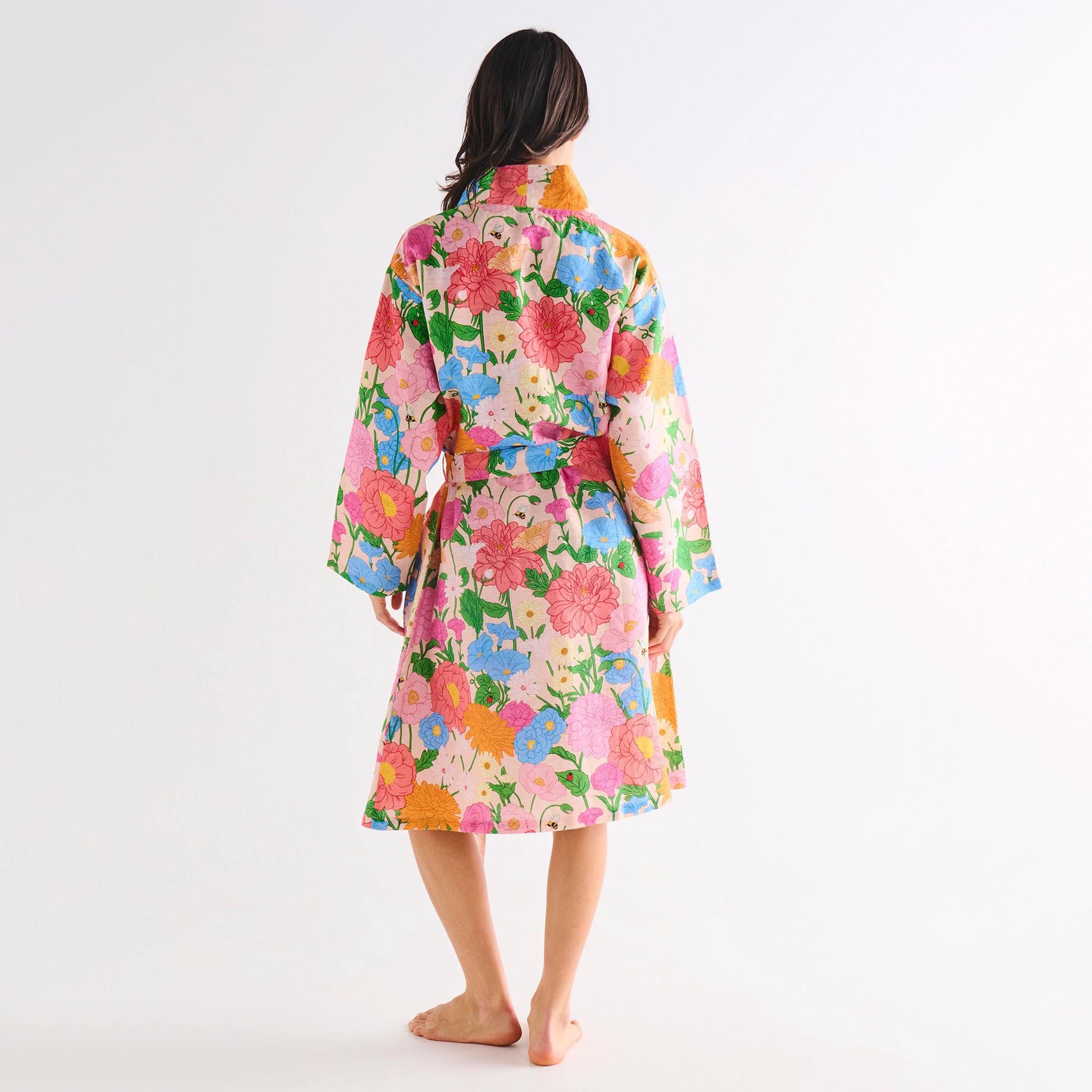 Person wearing a colorful floral robe on a white background