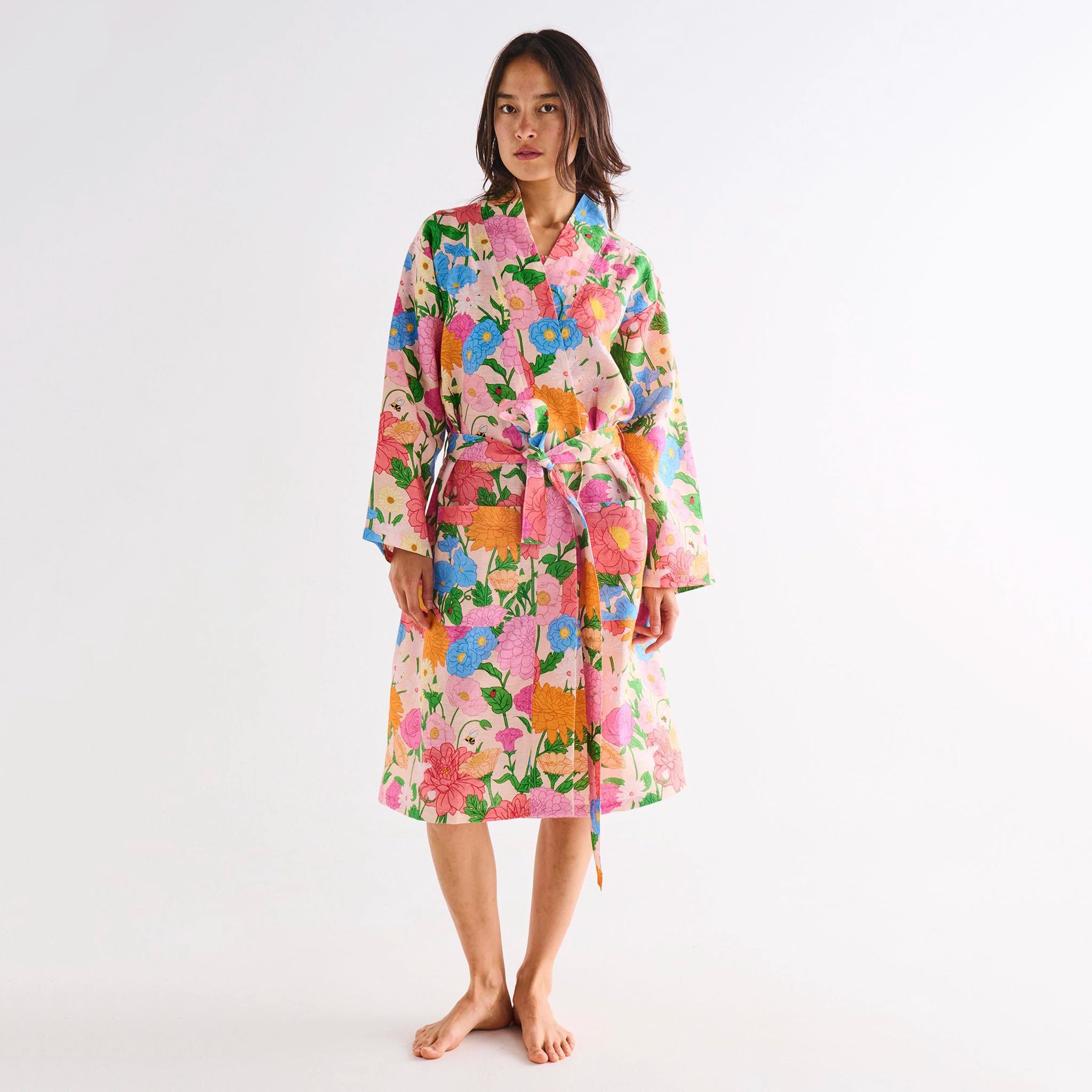Woman wearing a colorful floral robe on a white background