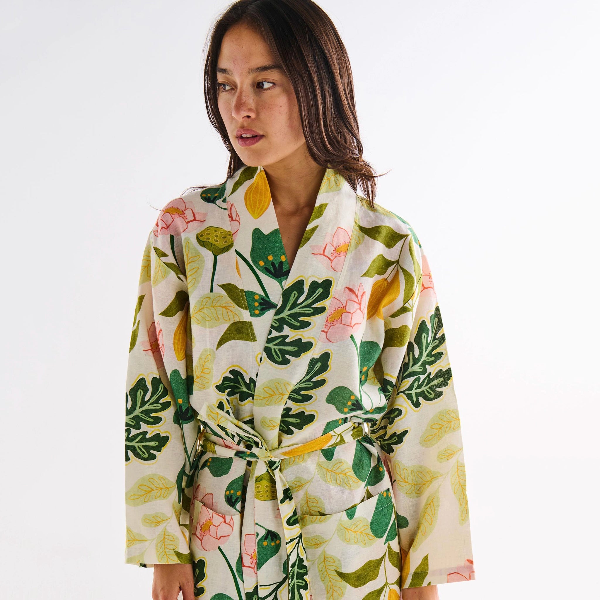 Woman wearing a floral and leaf patterned robe on a white background