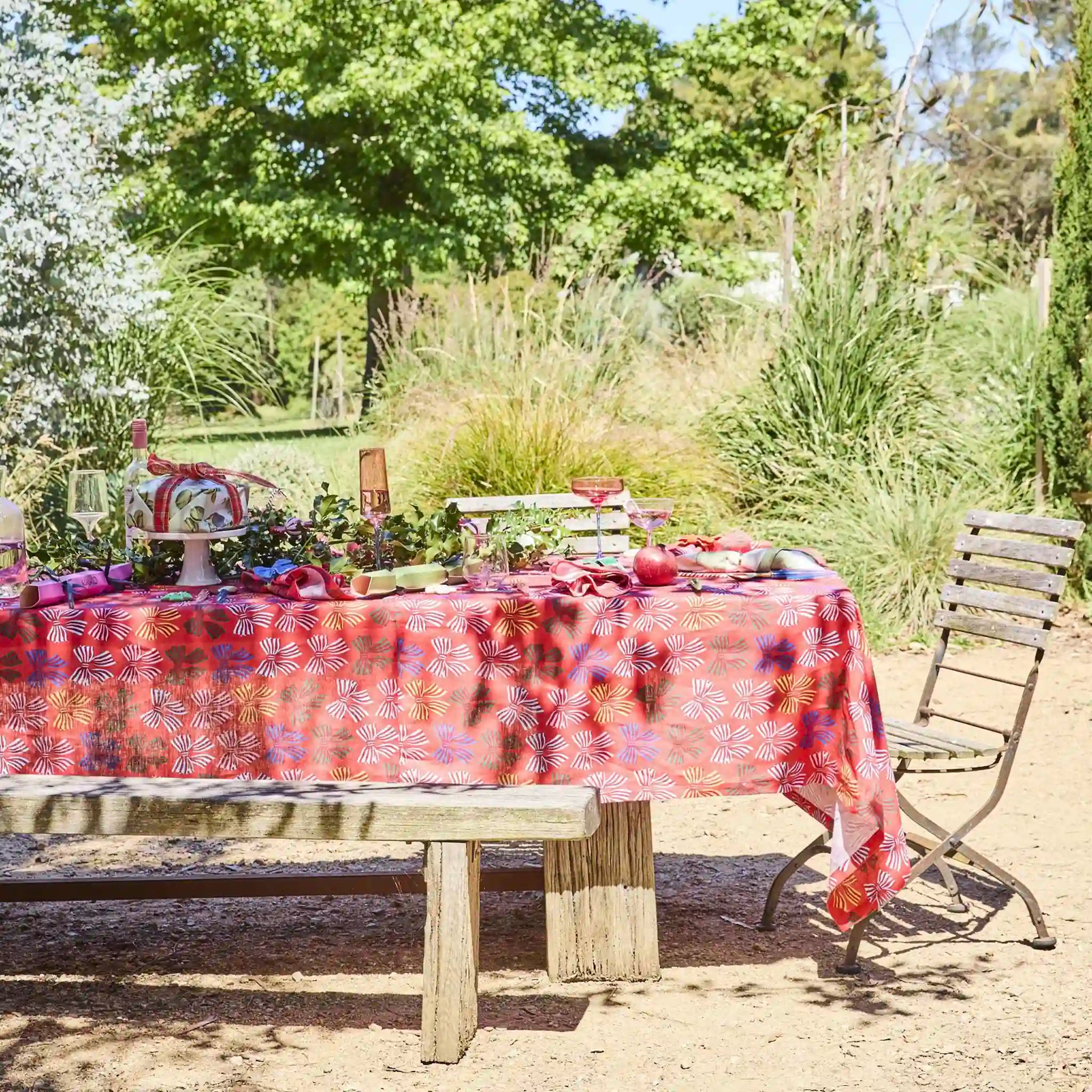 Outdoor table setting with a floral tablecloth in a garden