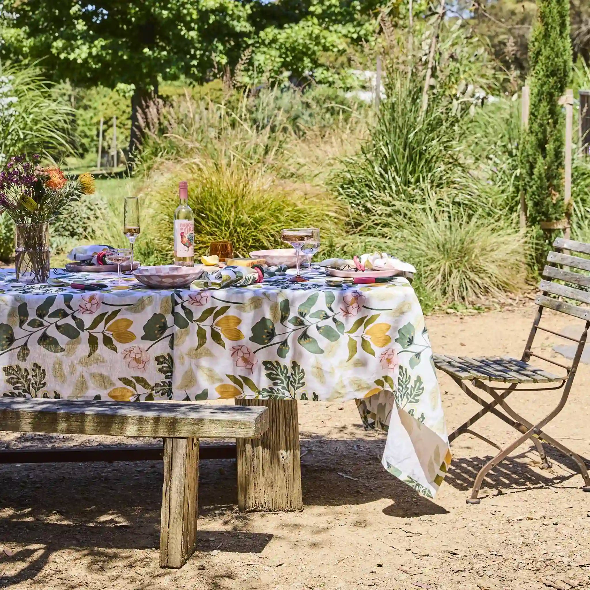 Outdoor setting with a table set for a meal in a garden.