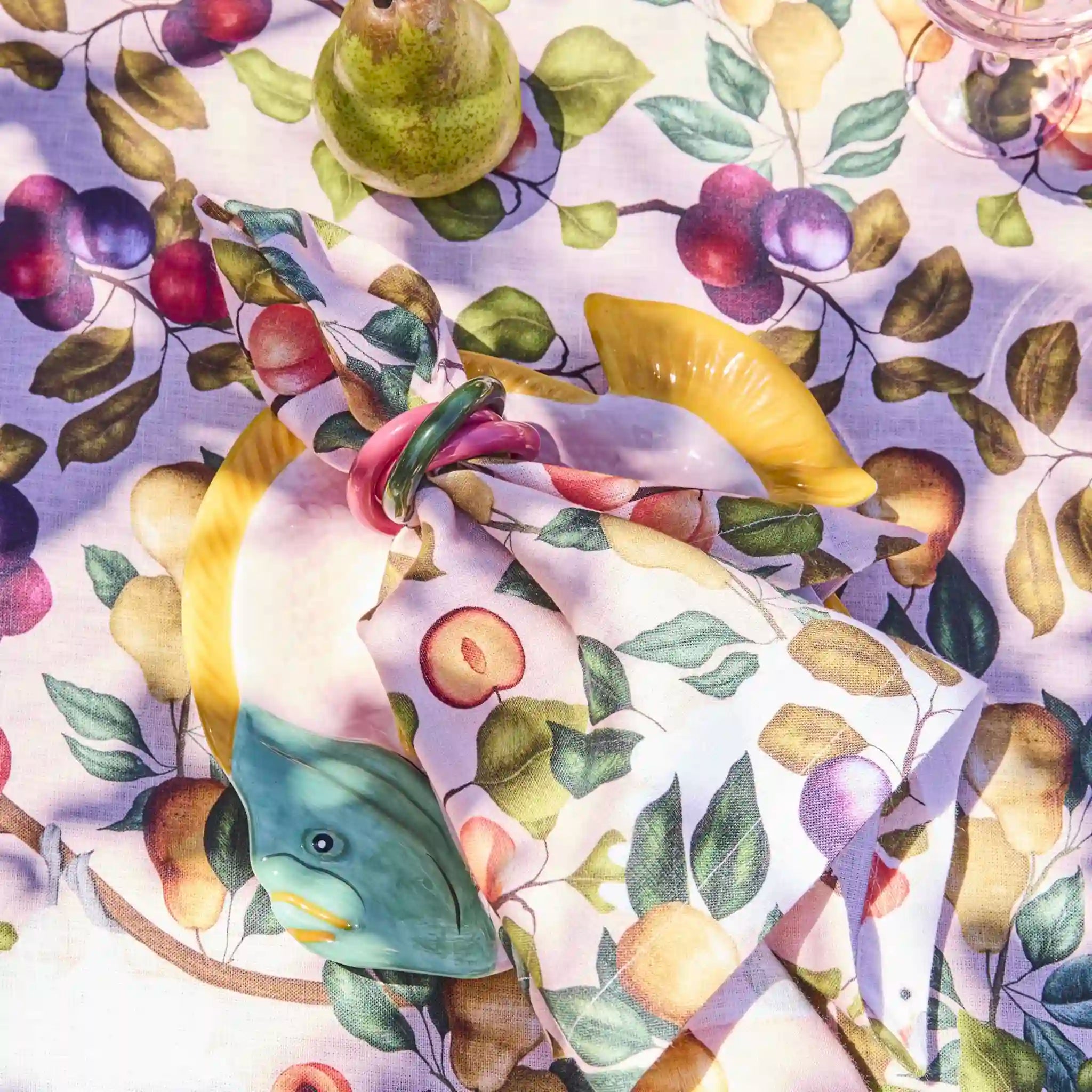 Fruit-patterned fabric with pears, apples, and lemons on a white background