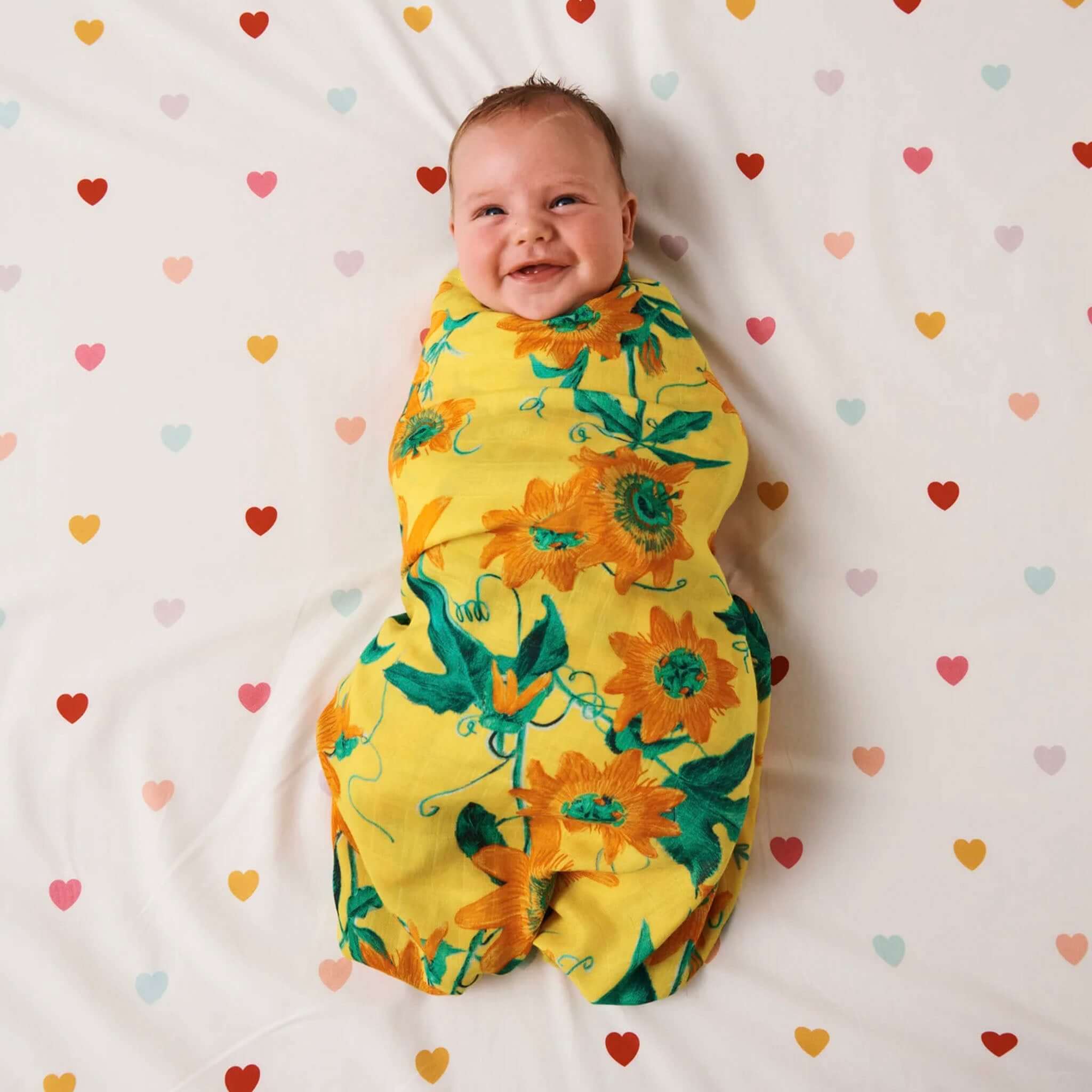 Kip & Co Organic  Cotton Baby Fitted Cot Sheet - I Heart You with baby on white sheet with colourful heart polka dots