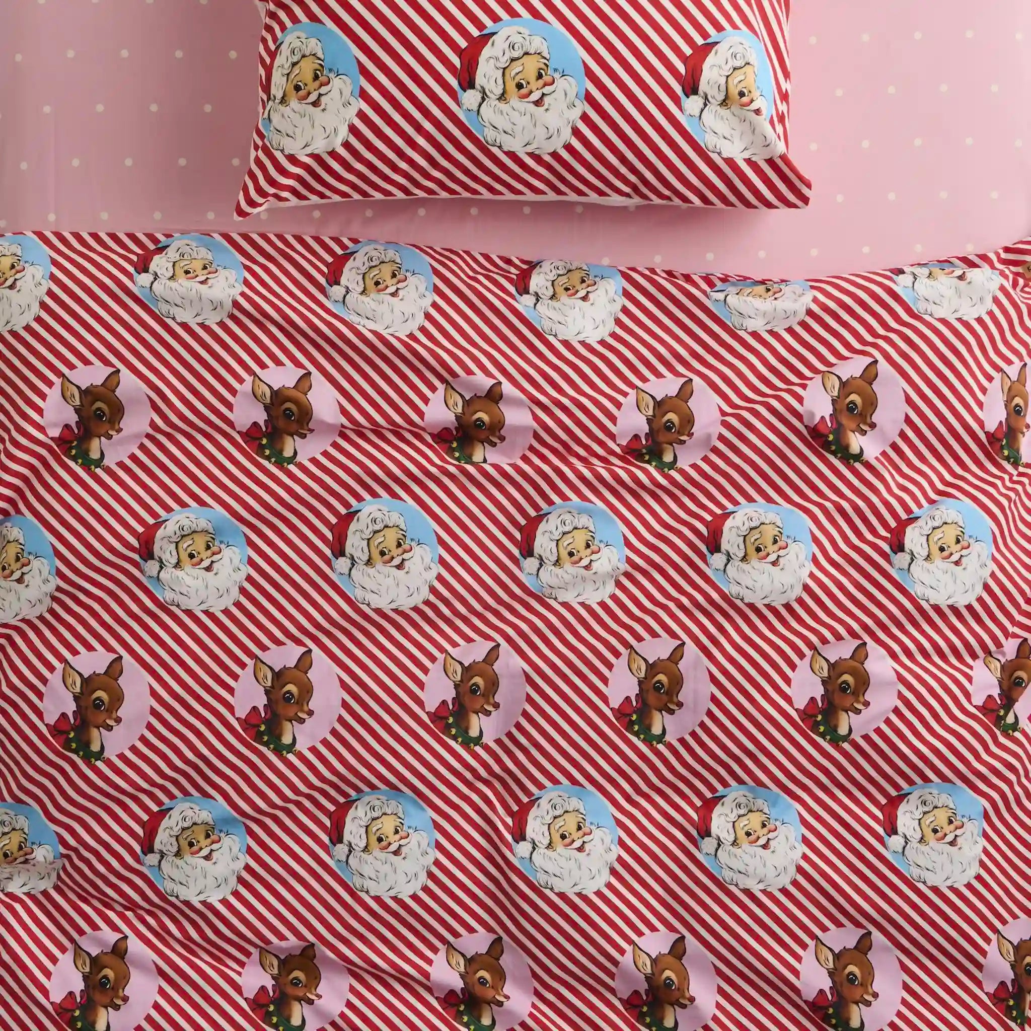 Christmas-themed quilt with reindeer and Santa Claus pattern on red and white striped background