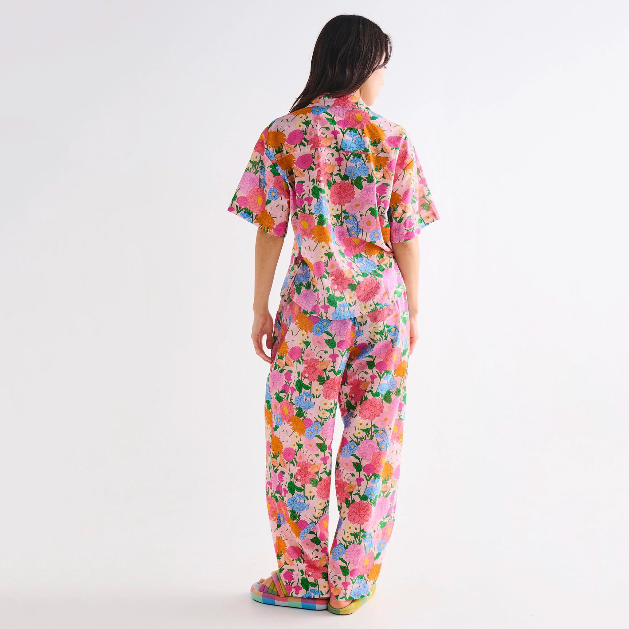 Woman wearing a colorful floral pyjamas on a white background