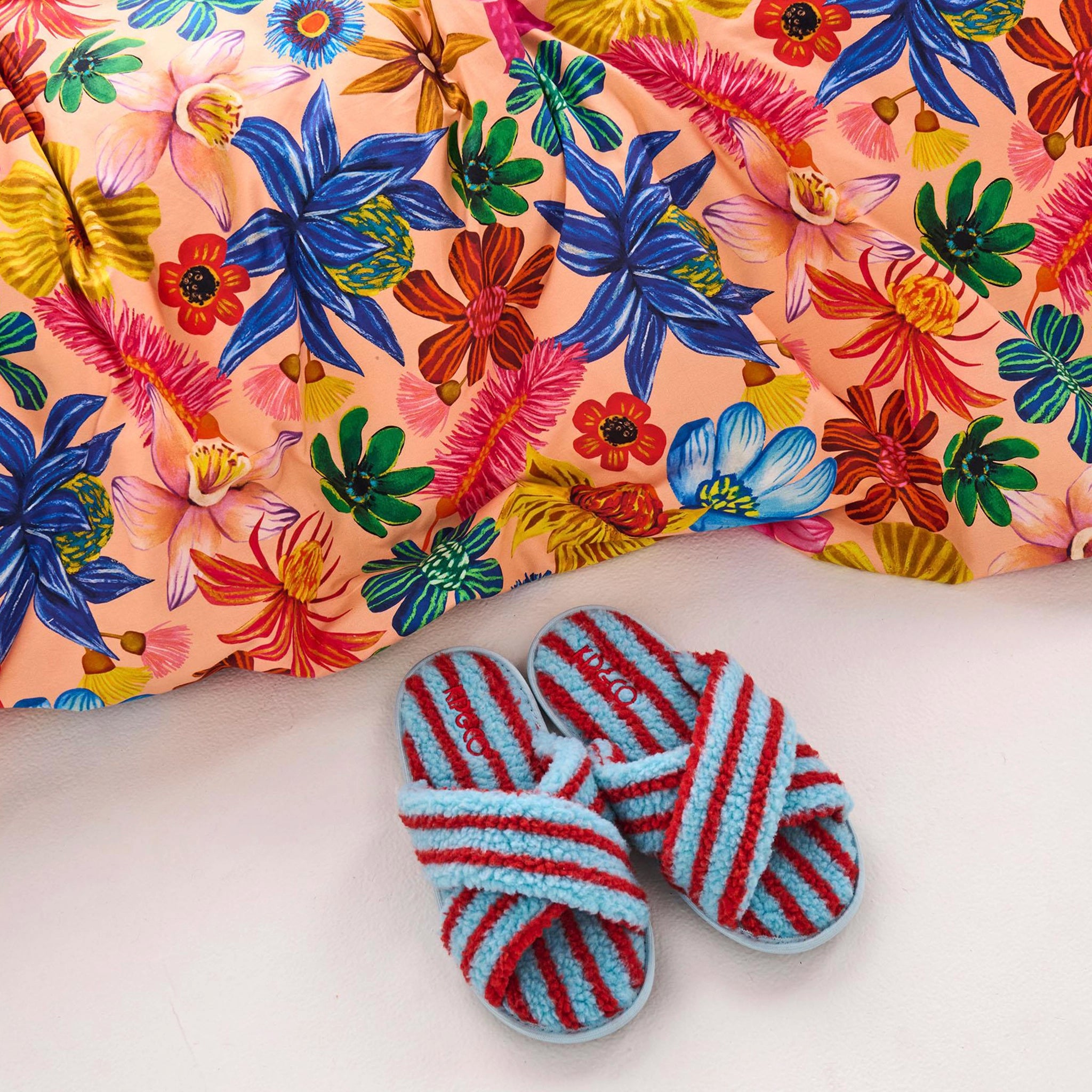 Striped slippers with a colorful floral-patterned fabric background