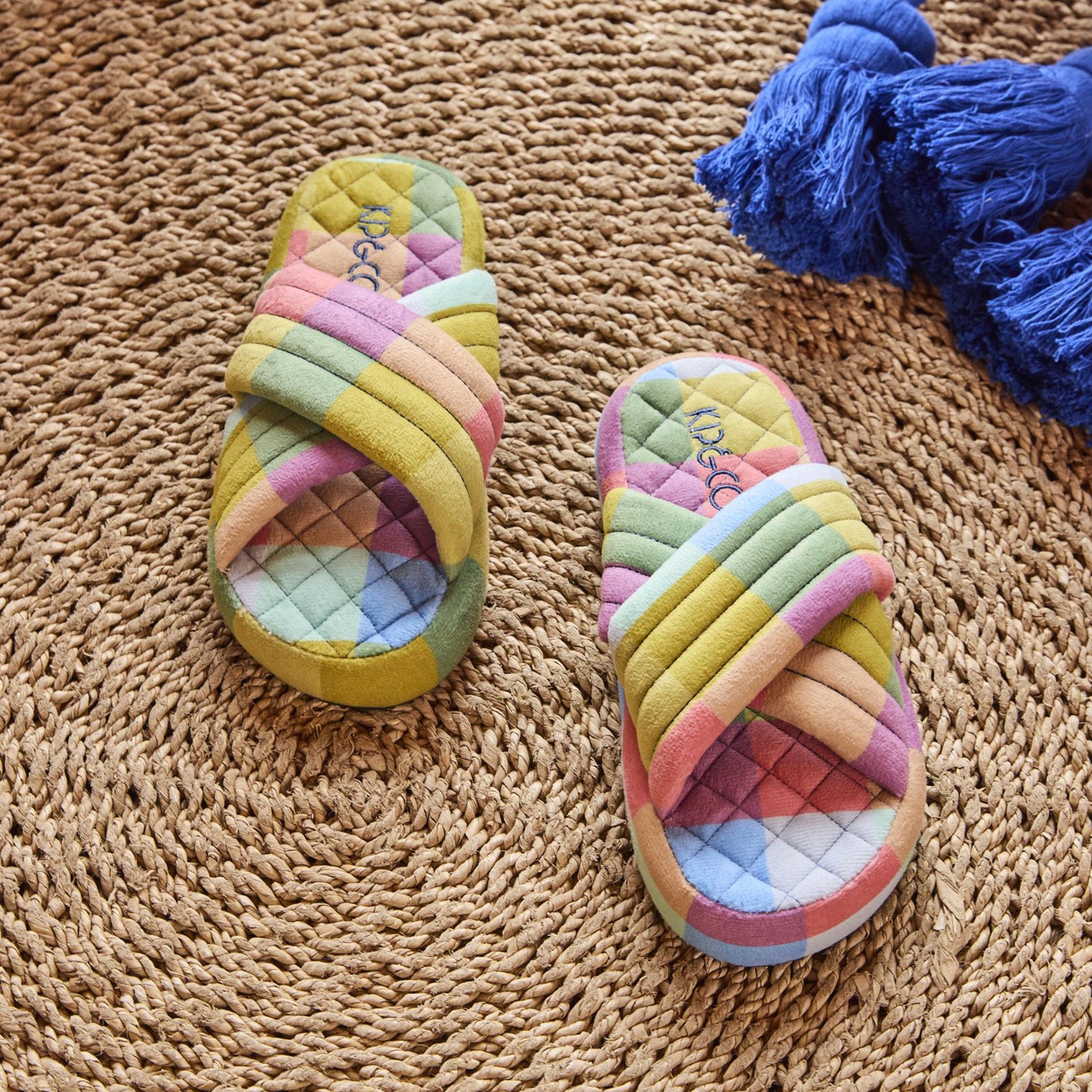 Pair of colorful quilted slippers on a textured surface