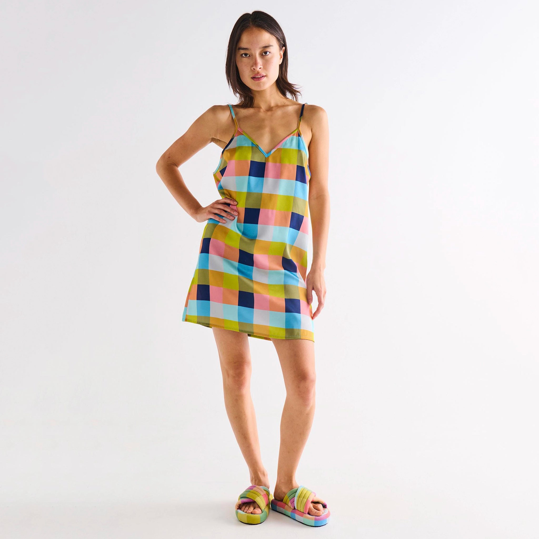 Woman wearing a colorful checkered dress on a white background
