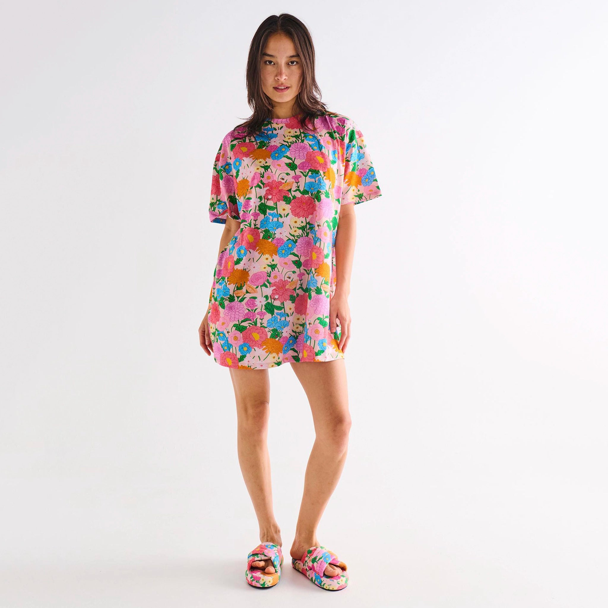 Woman wearing a colorful floral dress on a white background